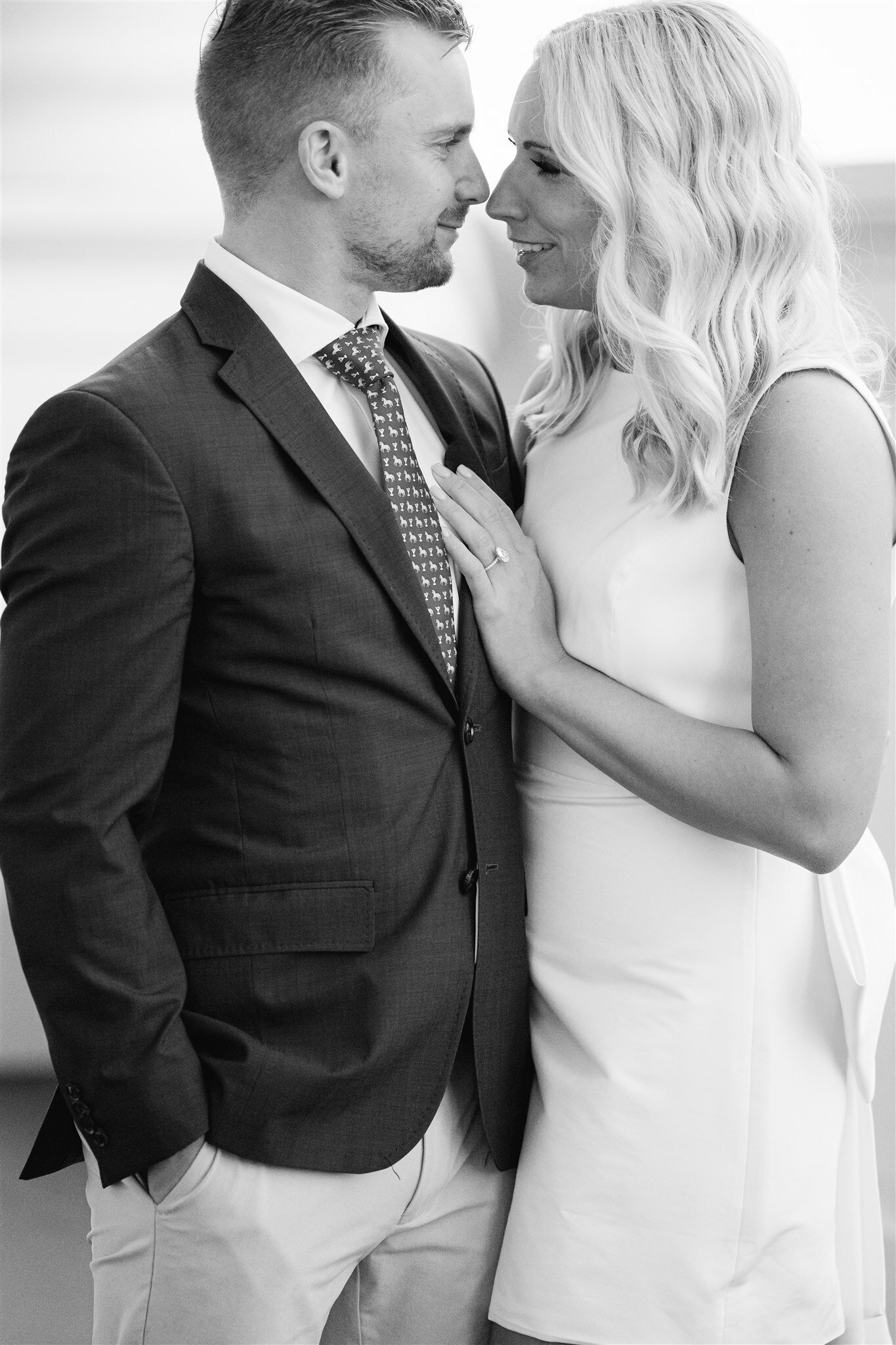 woman's hand placed on her fiance's chest, with a beautiful ring in view.
