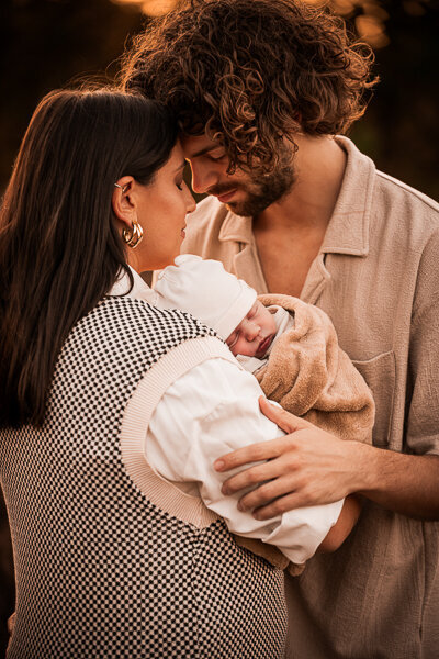 Een newborn fotoshoot in de natuur, omringt door de ouders en trouwe hond