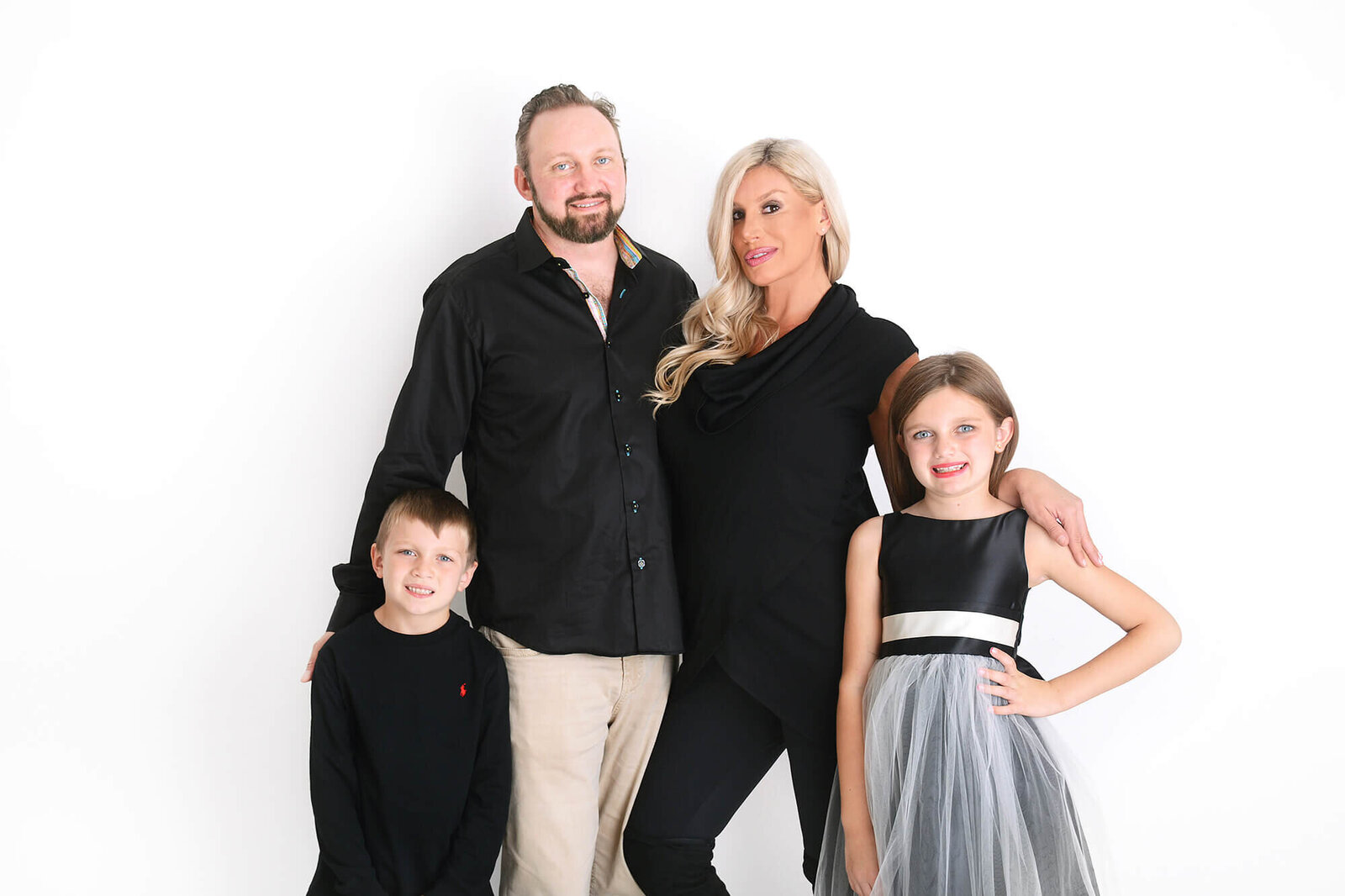 family poses and smiles at their family photoshoot in houston texas