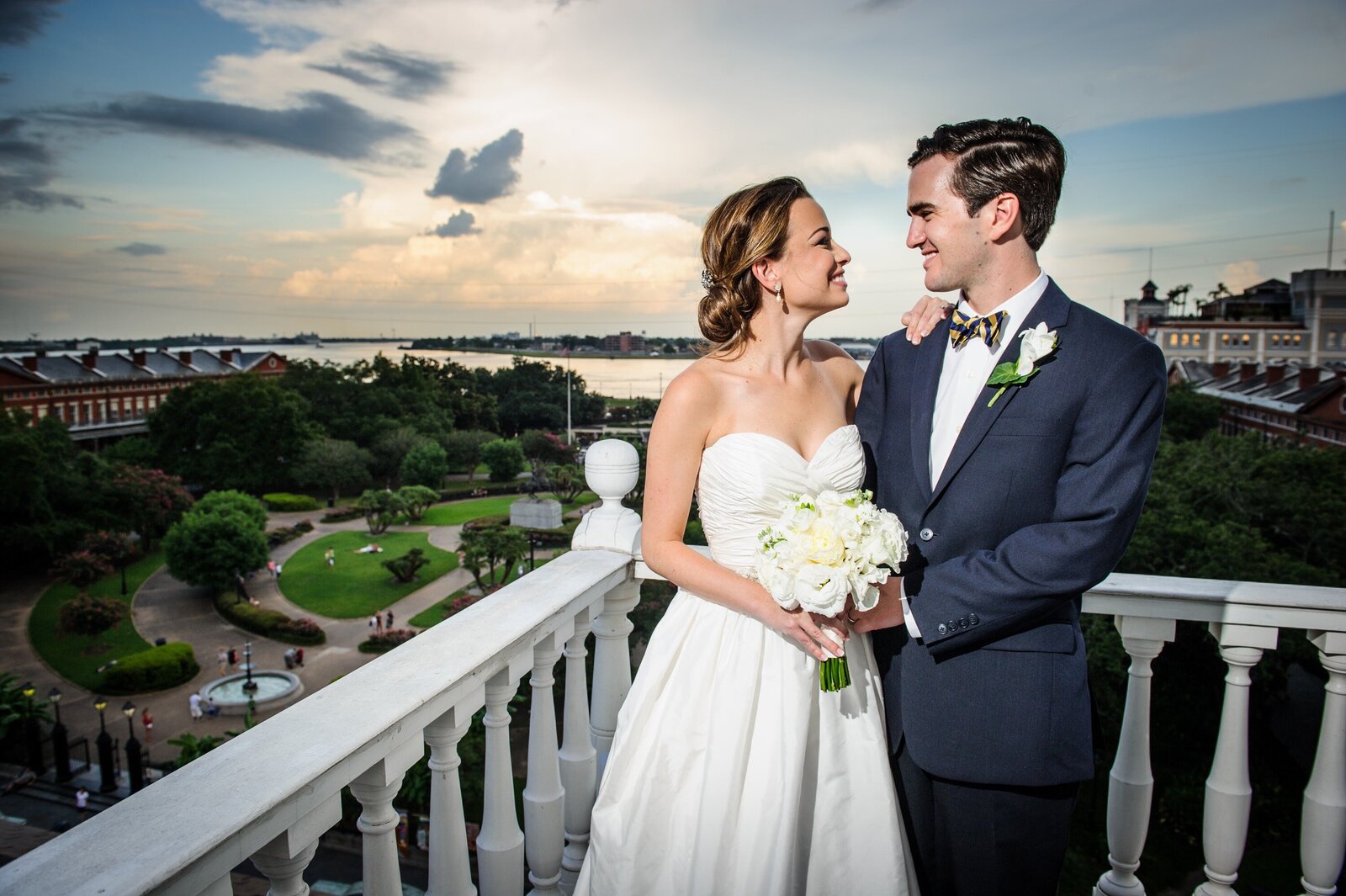 Bride and groom on top of Cabildo in New Orleans with sunset in background