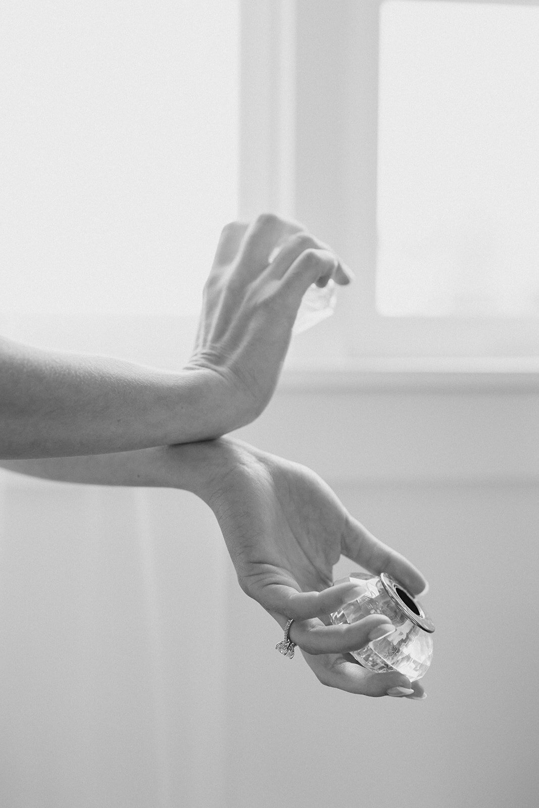 wrists rub together while holding perfume top