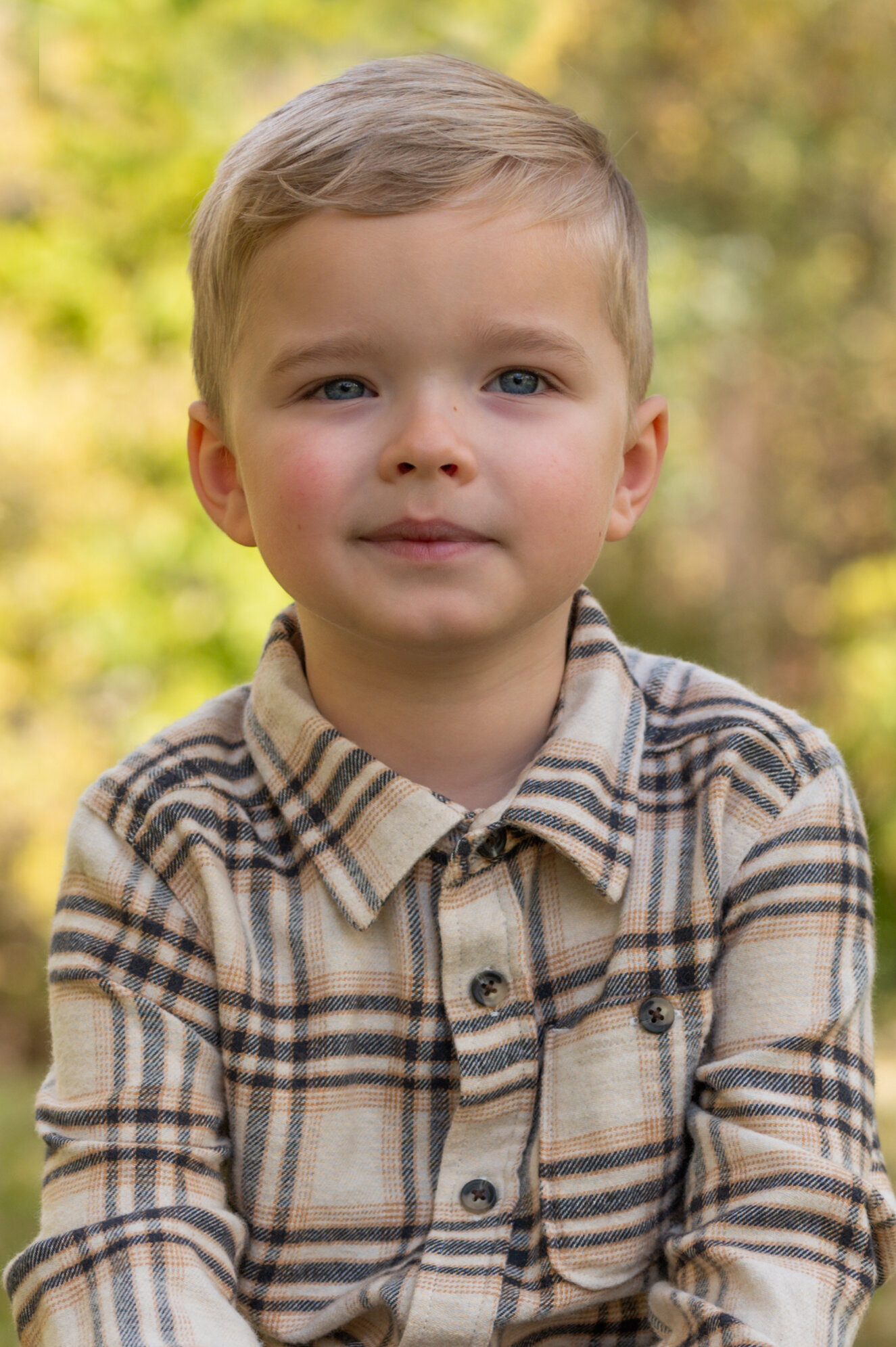 preschool boy sitting outdoors for school picture