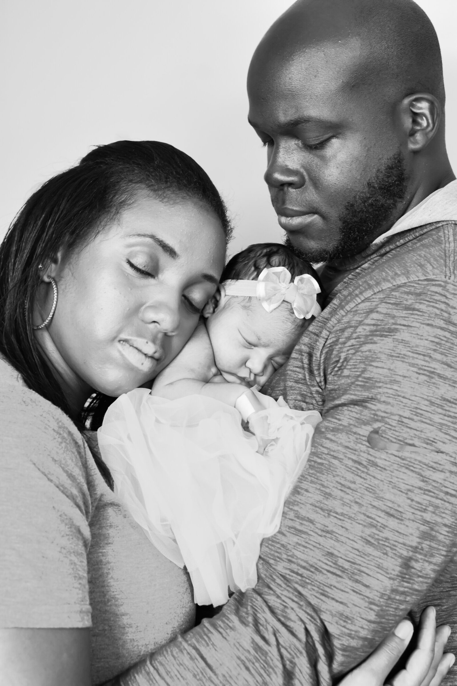black and white photo of a mother and father holding their newborn baby girl photographed by Millz Photography in Greenville, SC