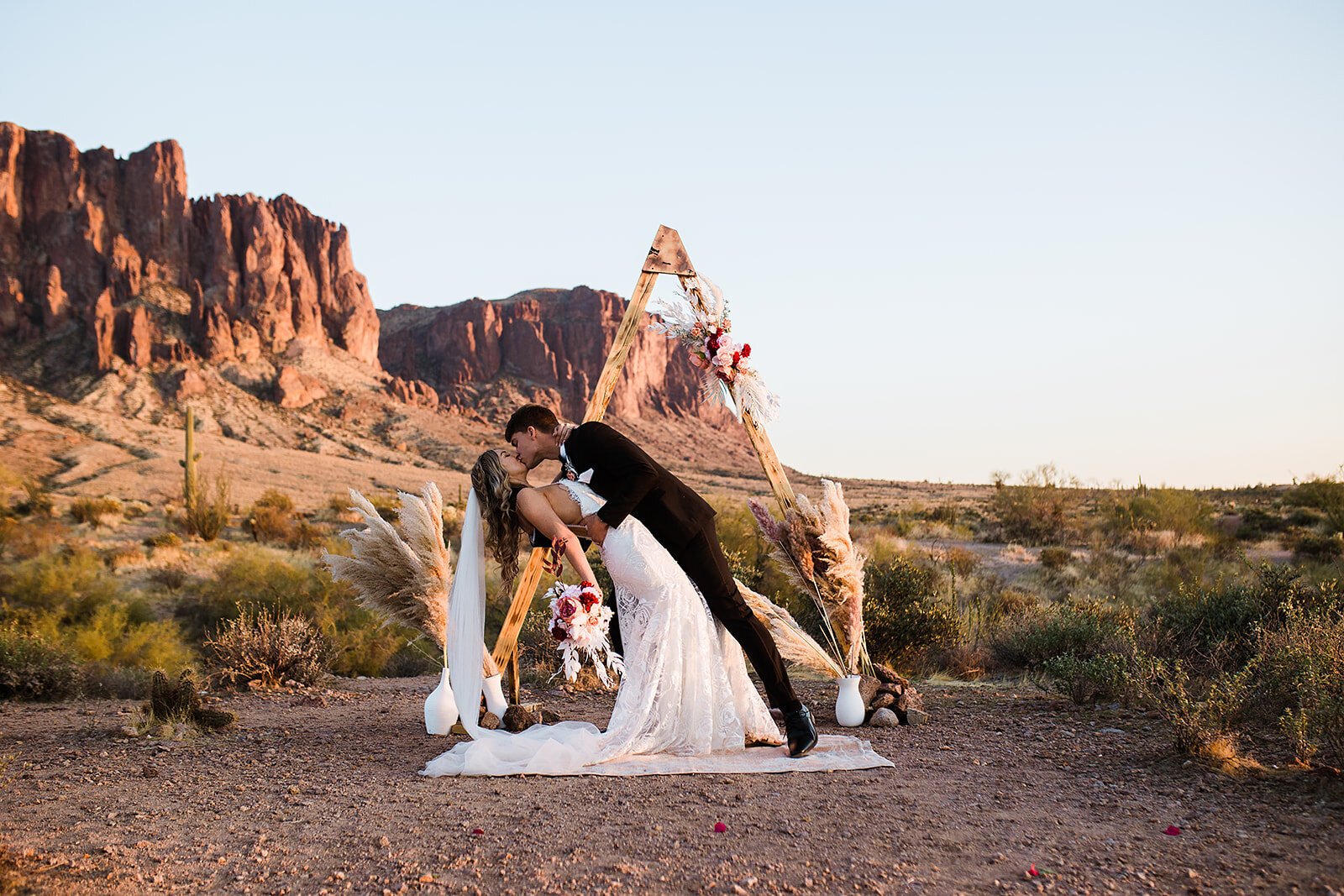 Bride and groom in a deep kiss with the mountains in the background