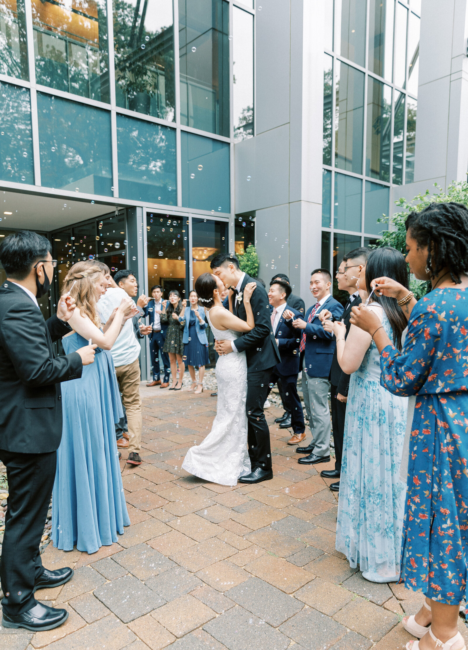 Wedding exit with bubbles while the bride and groom kiss