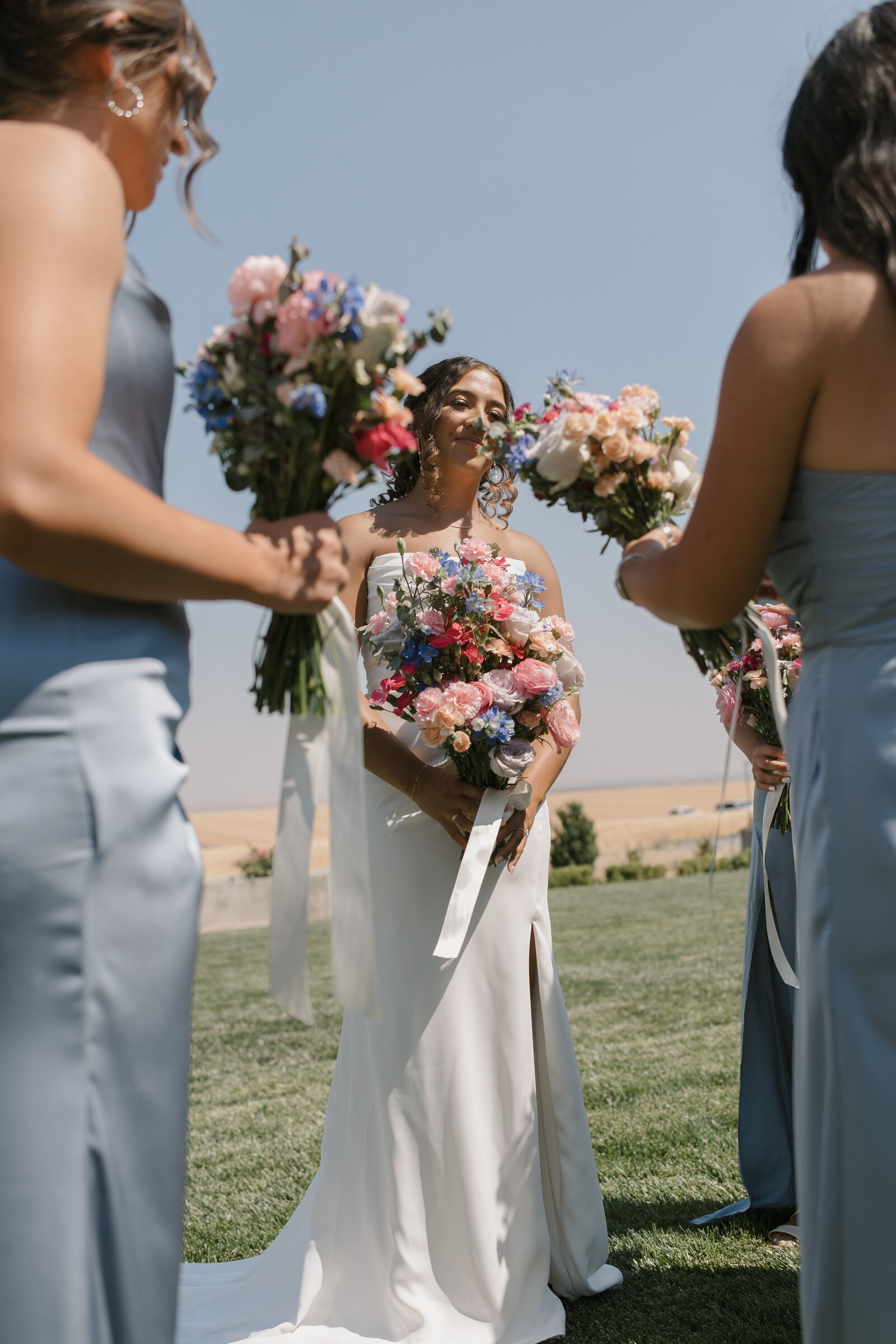 editorial photo of bride with her bridesmaids holding their boquets