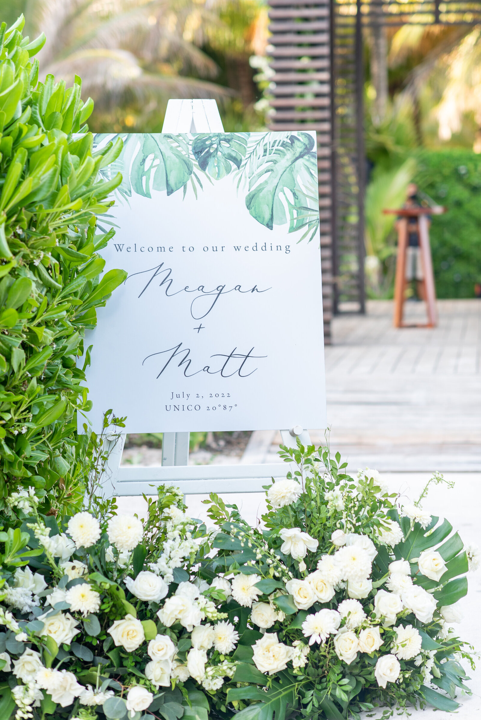outdoor beach wedding welcome sign with flowers