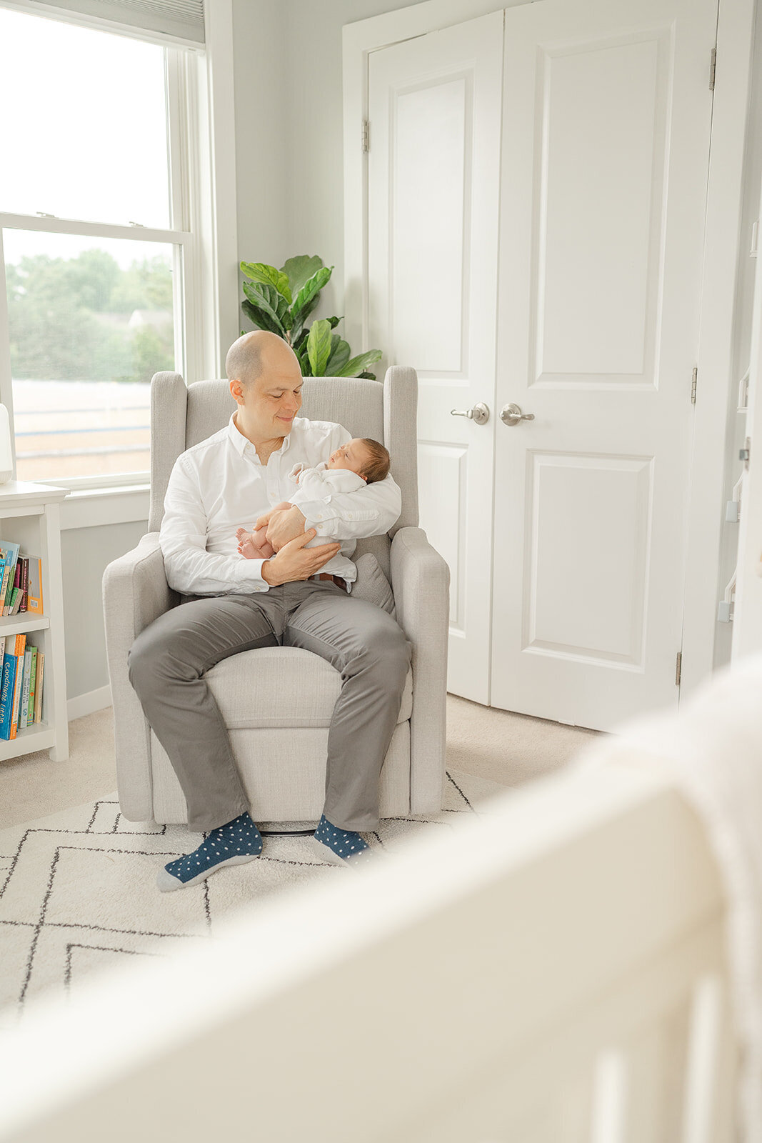 dad smiling as he looks at baby during Haymarket, VA newborn photo
