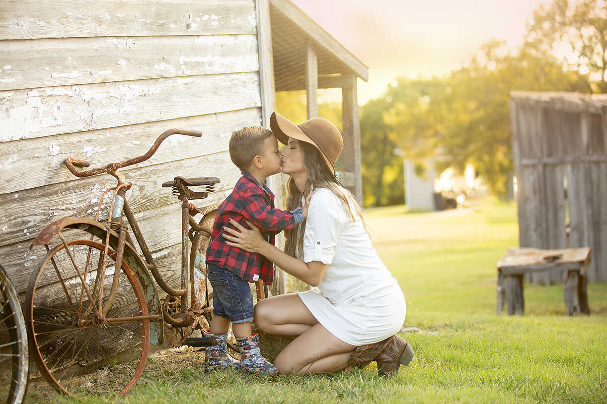 Mother kissing young son during family phtotshoot