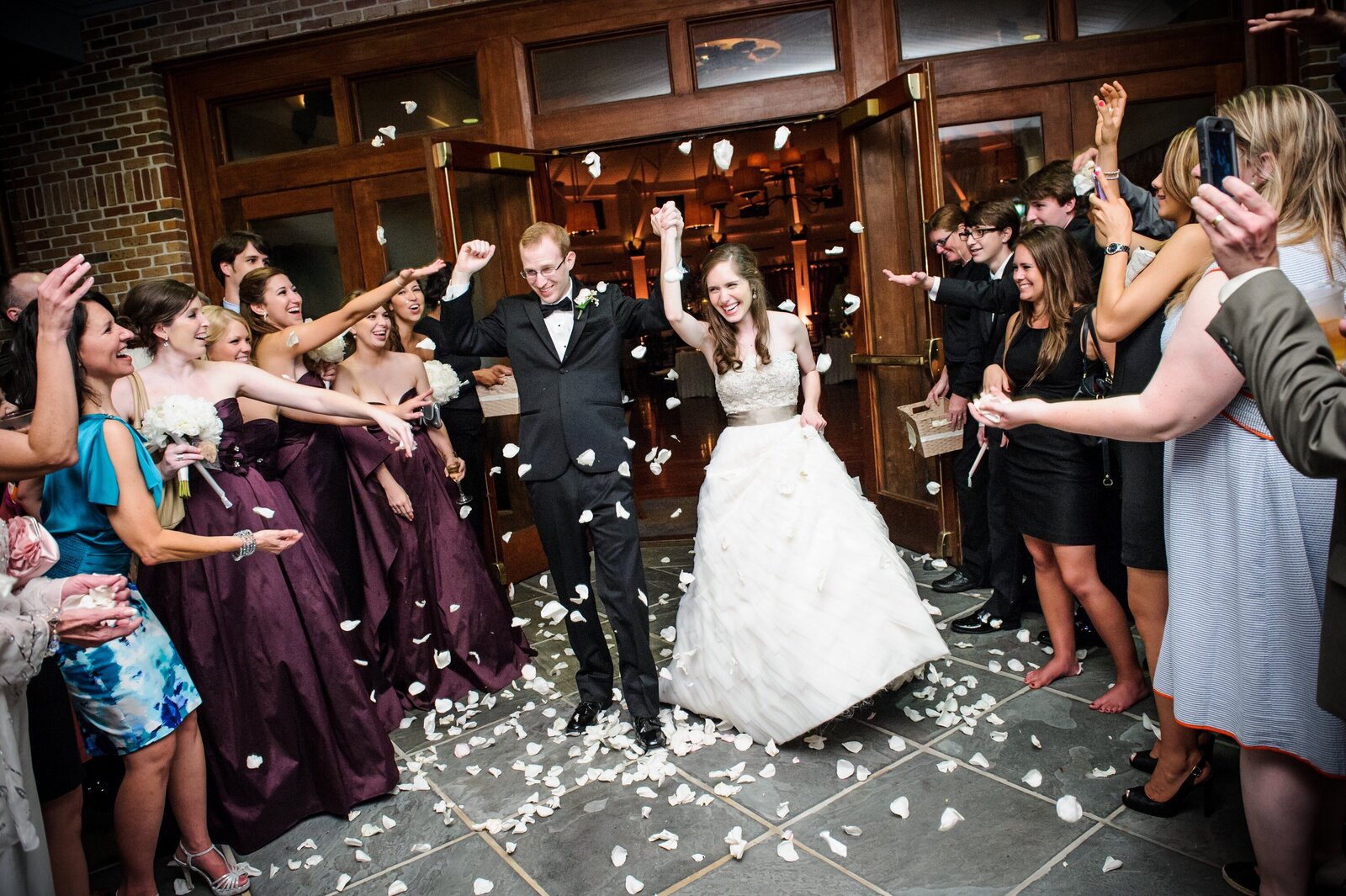 Bride and groom walking through flower petal send-off at Audubon Tea Room wedding