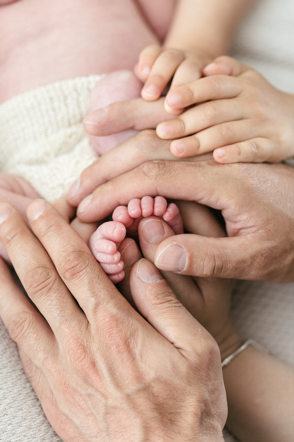 Babies toes held by mum and dads hands
