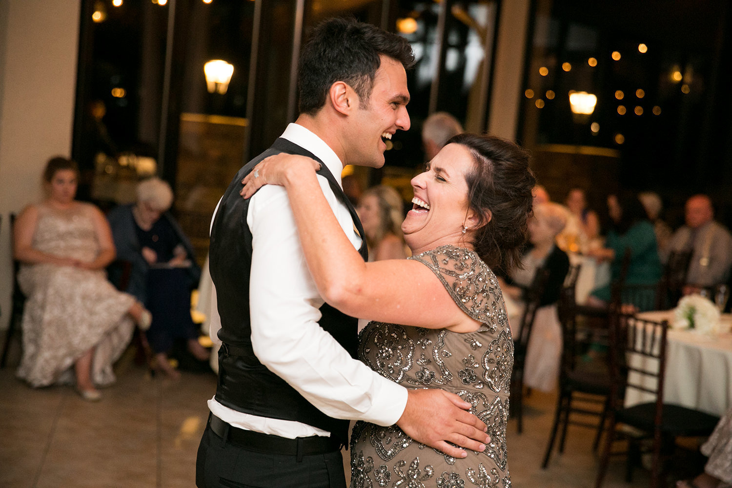 groom and his mom dancing laughing