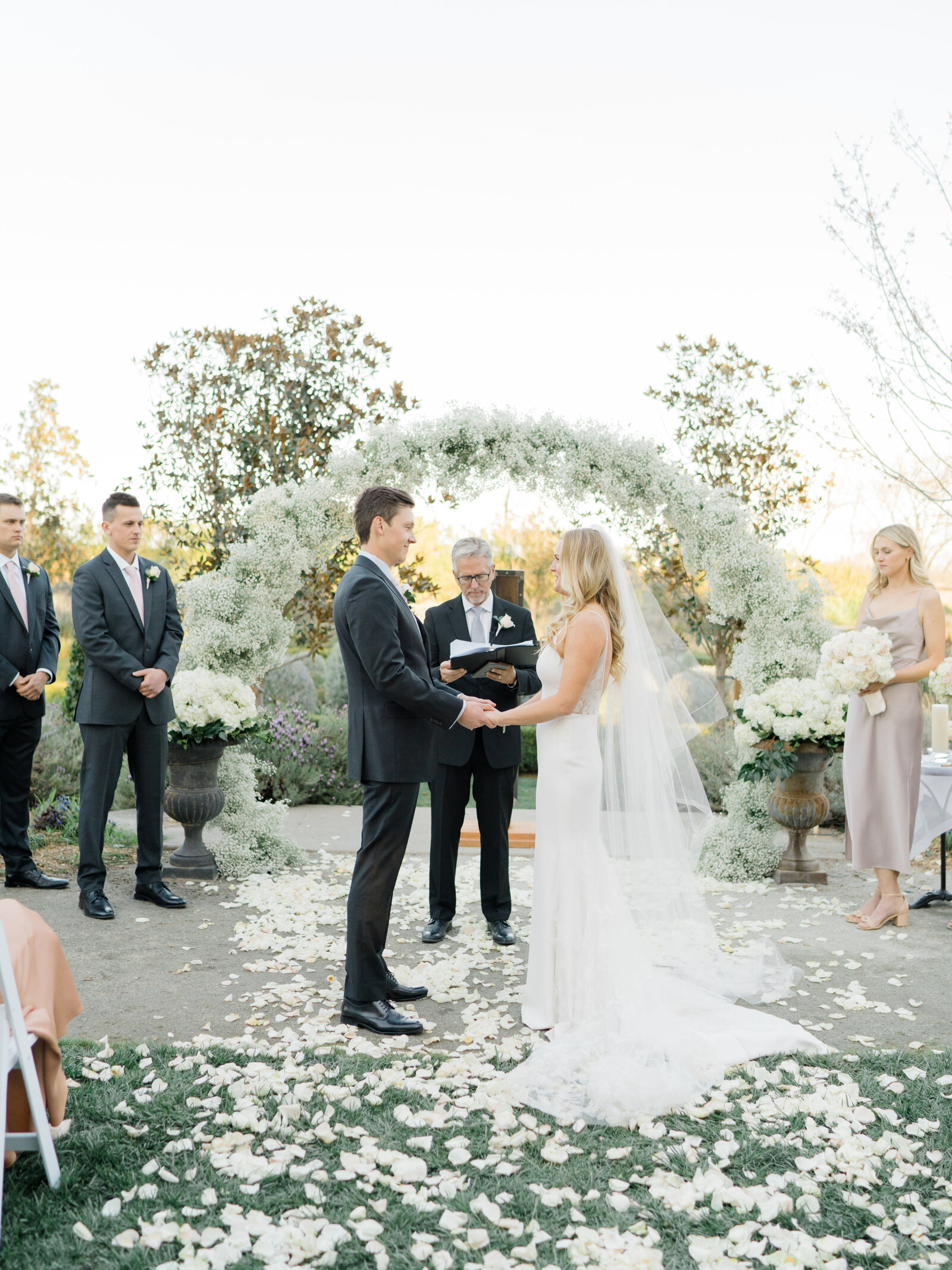 bride and groom exchanging vows at an outdoor ceremony