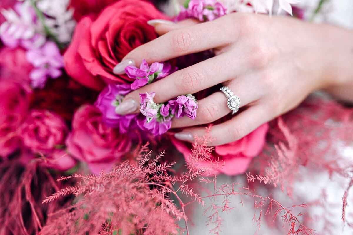 close up photo of bride holding pink bouquet to show off wedding ring