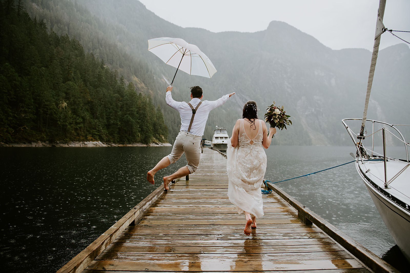 Couple happily running down the dock, in the rain after their beautiful Chatterbox falls elopement with Coastal Weddings and events.