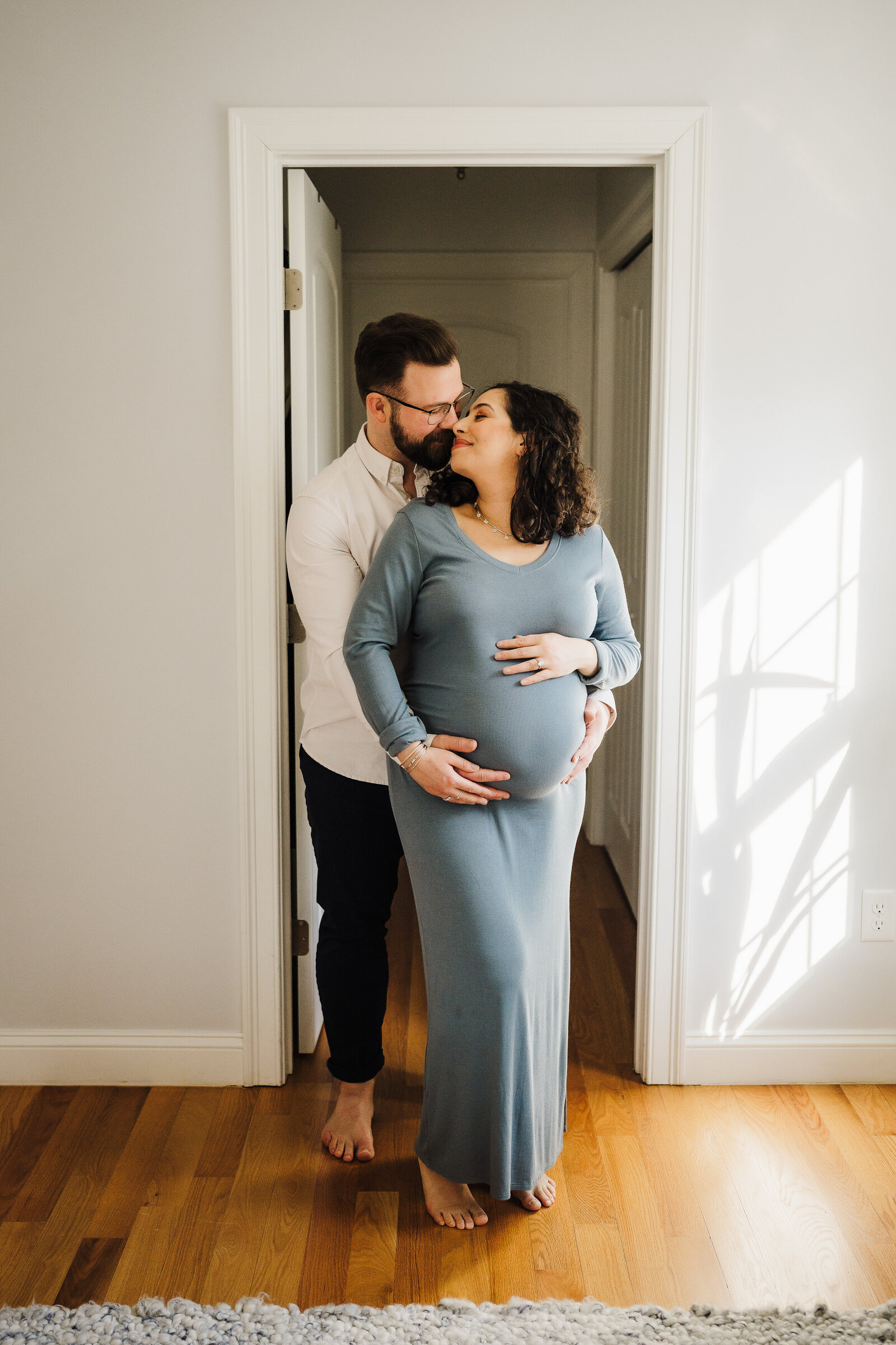 maternity couple poses for photos in home