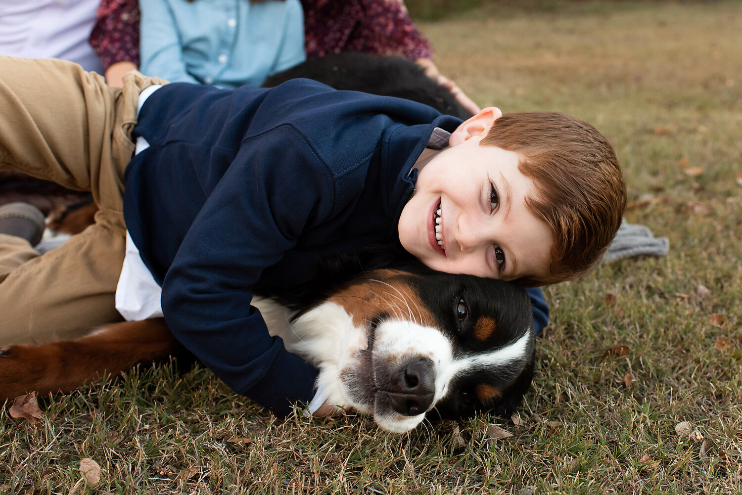 A young boy cuddling is large dog.
