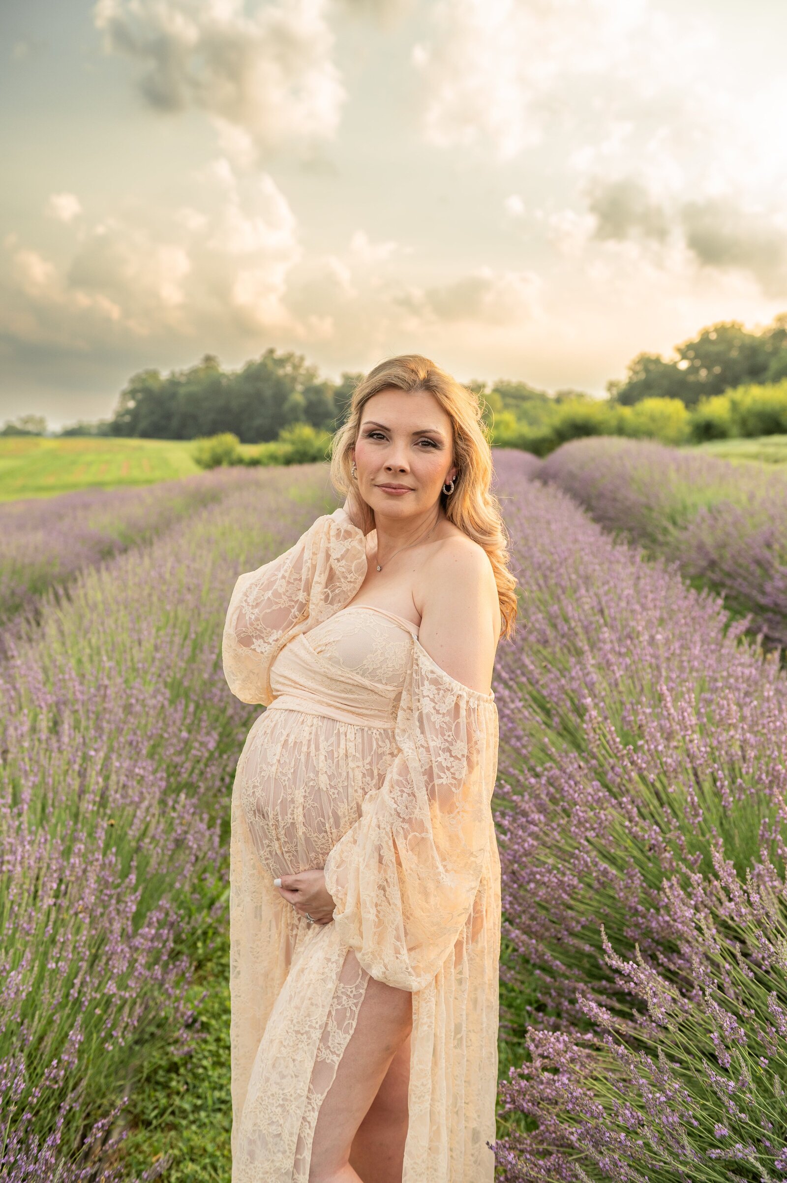 Pregnant woman at a lavender fied for a maternity photoshoot