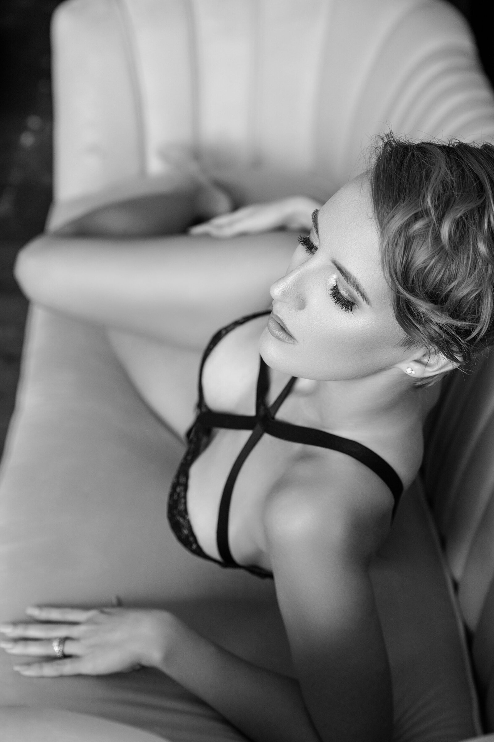 Woman in black lingerie laying on sofa in Baton Rouge boudoir studio.