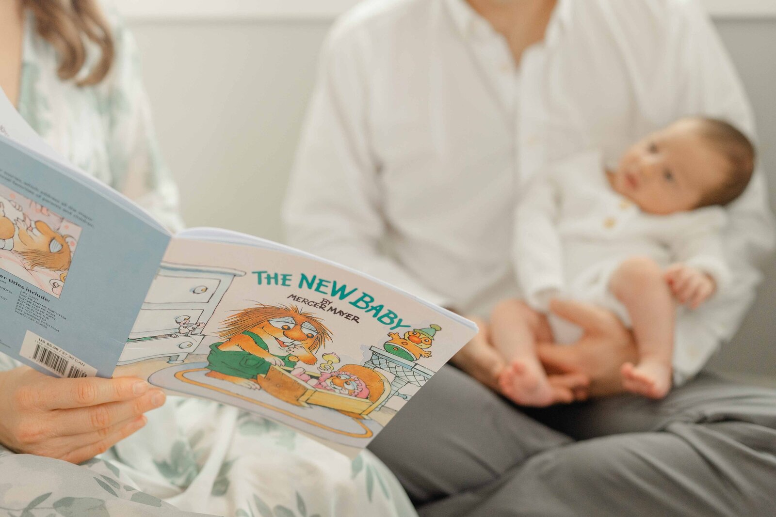 mom reading a book to baby during newborn session in Centreville, Virginia