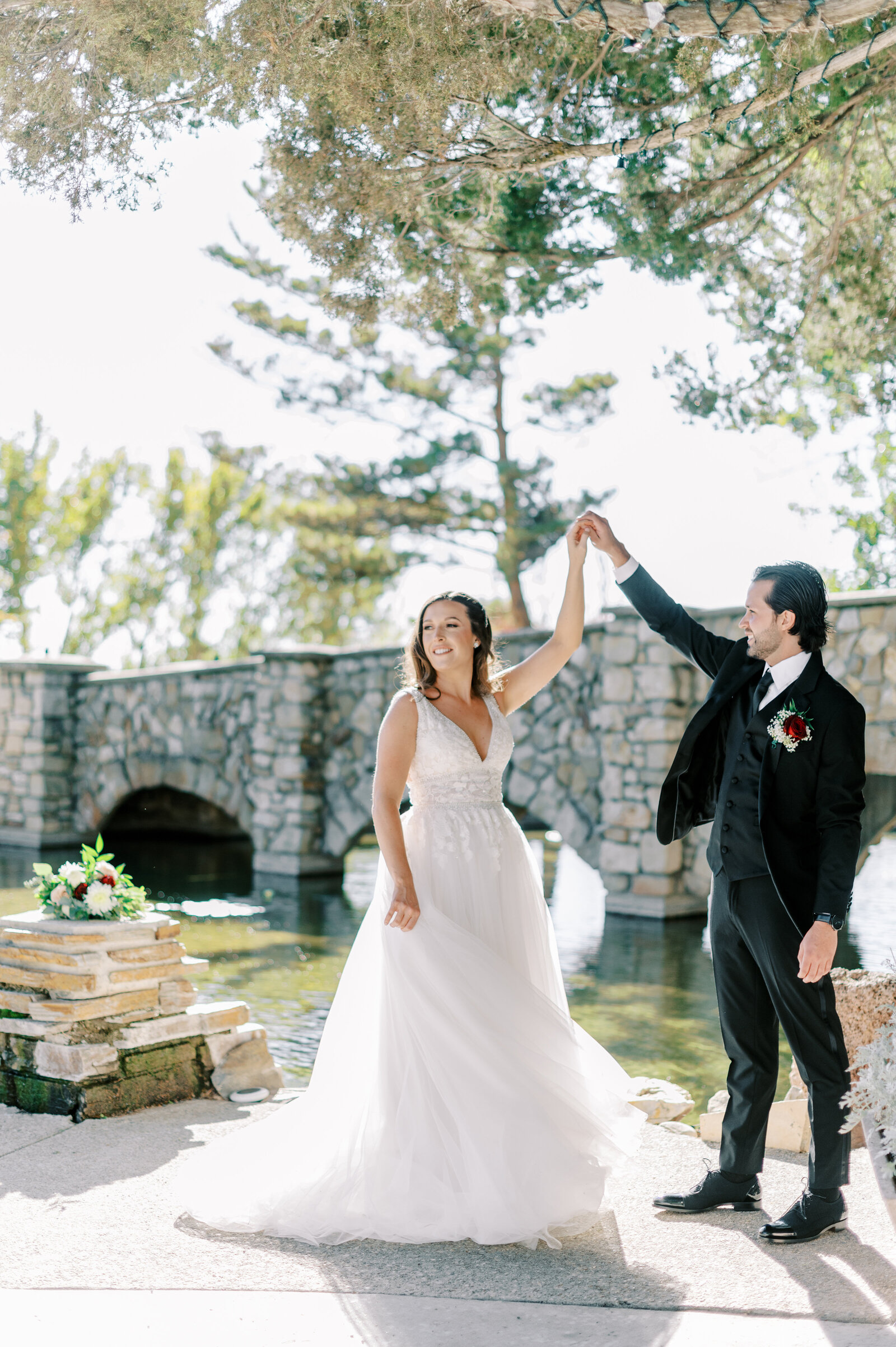 Boise wedding photography at stone crossing with groom twirling bride near the bridge