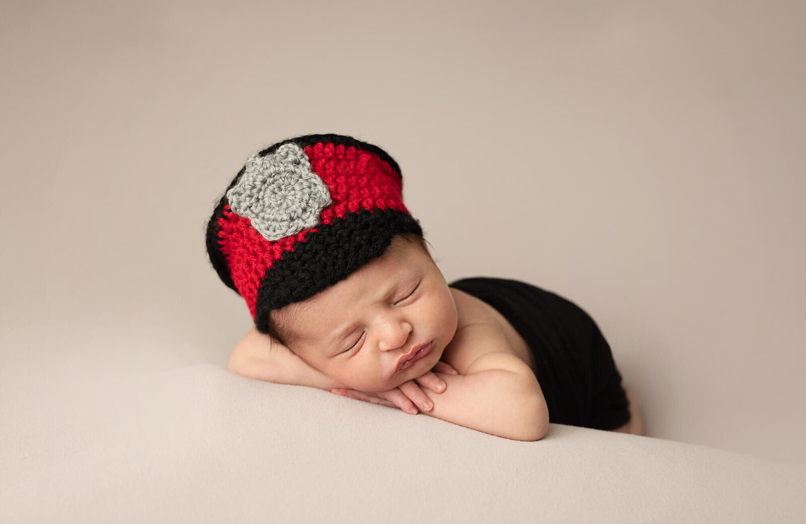 posed newborn baby boy in crochet police hat
