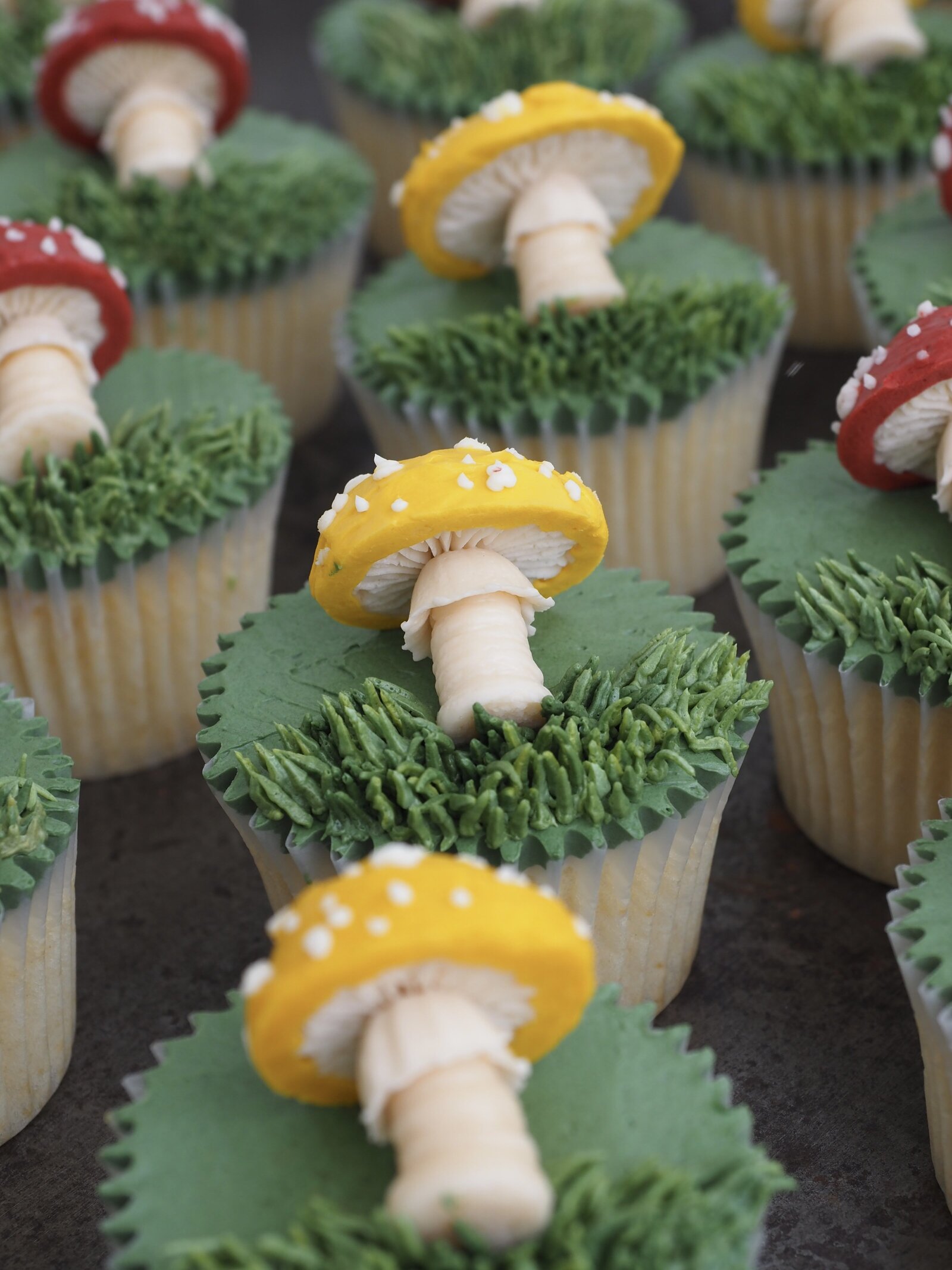 Cupcakes that have buttercream mushrooms on them