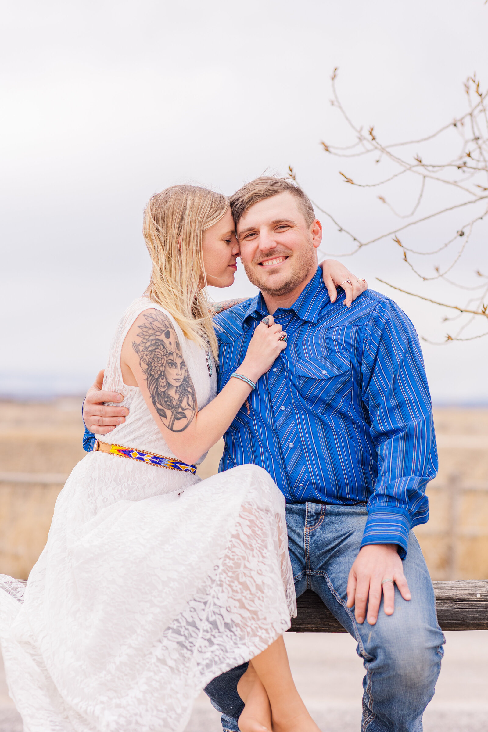 girl in lace white dress with fiancè in blue shirt and  jeans