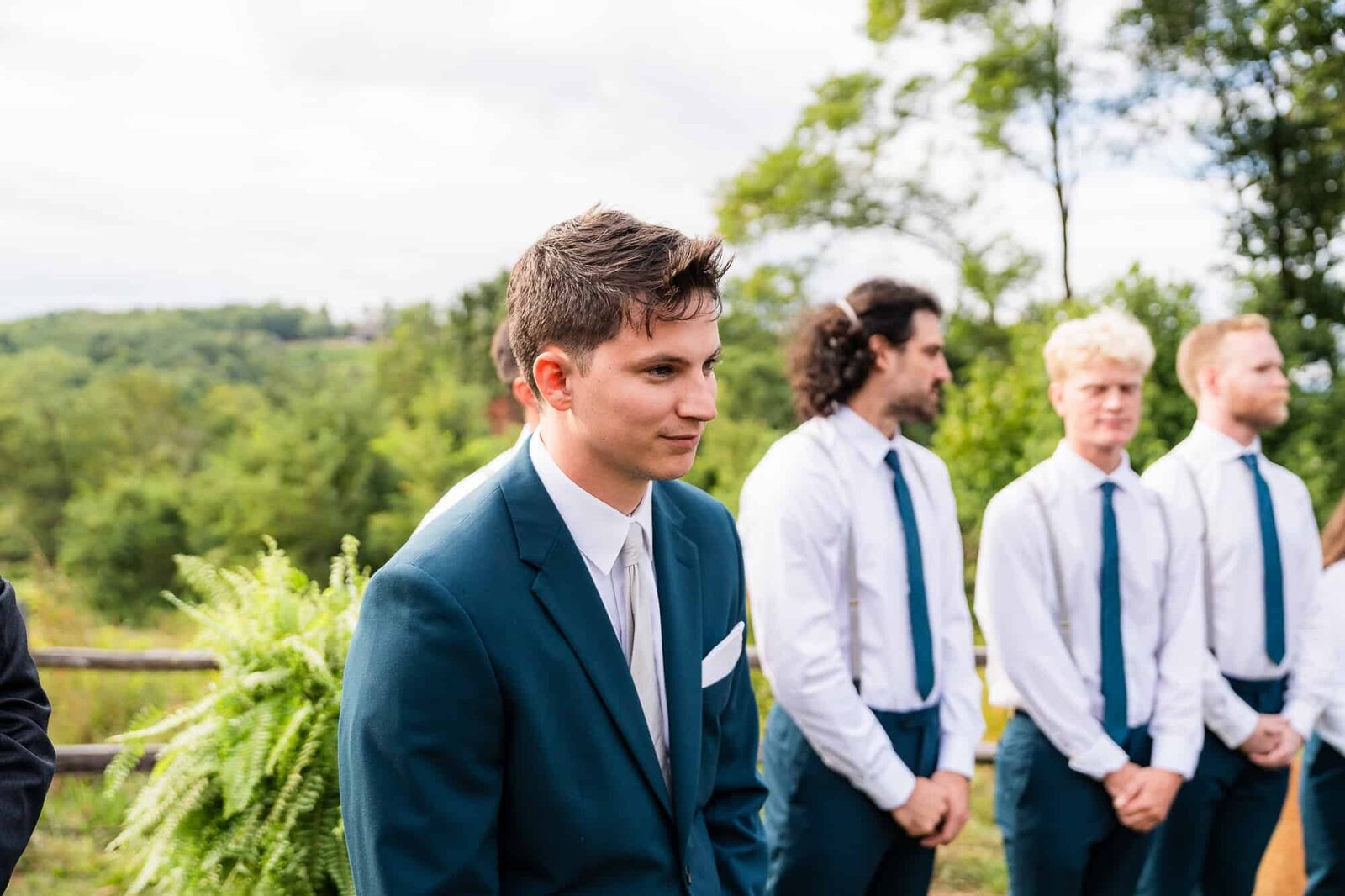 groom watching his bride walking sown the aisle at their wedding in the Georgia mountains