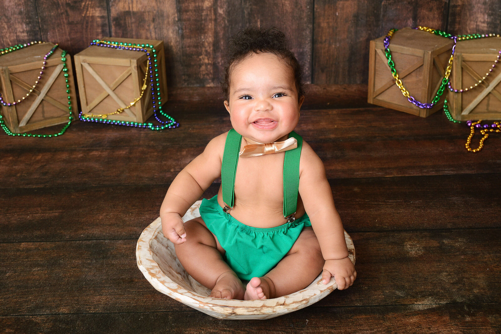 boy smiles at a rustic wooden photoshoot
