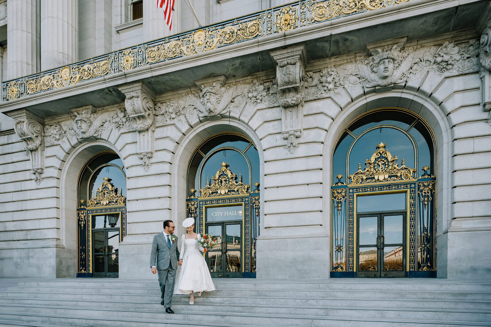 couple walking on the front steps of sf city hall 