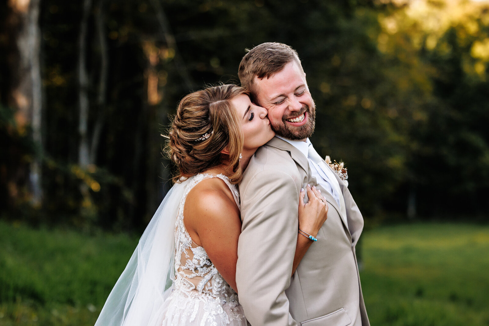 bride sweetly kisses her groom's cheek from behind
