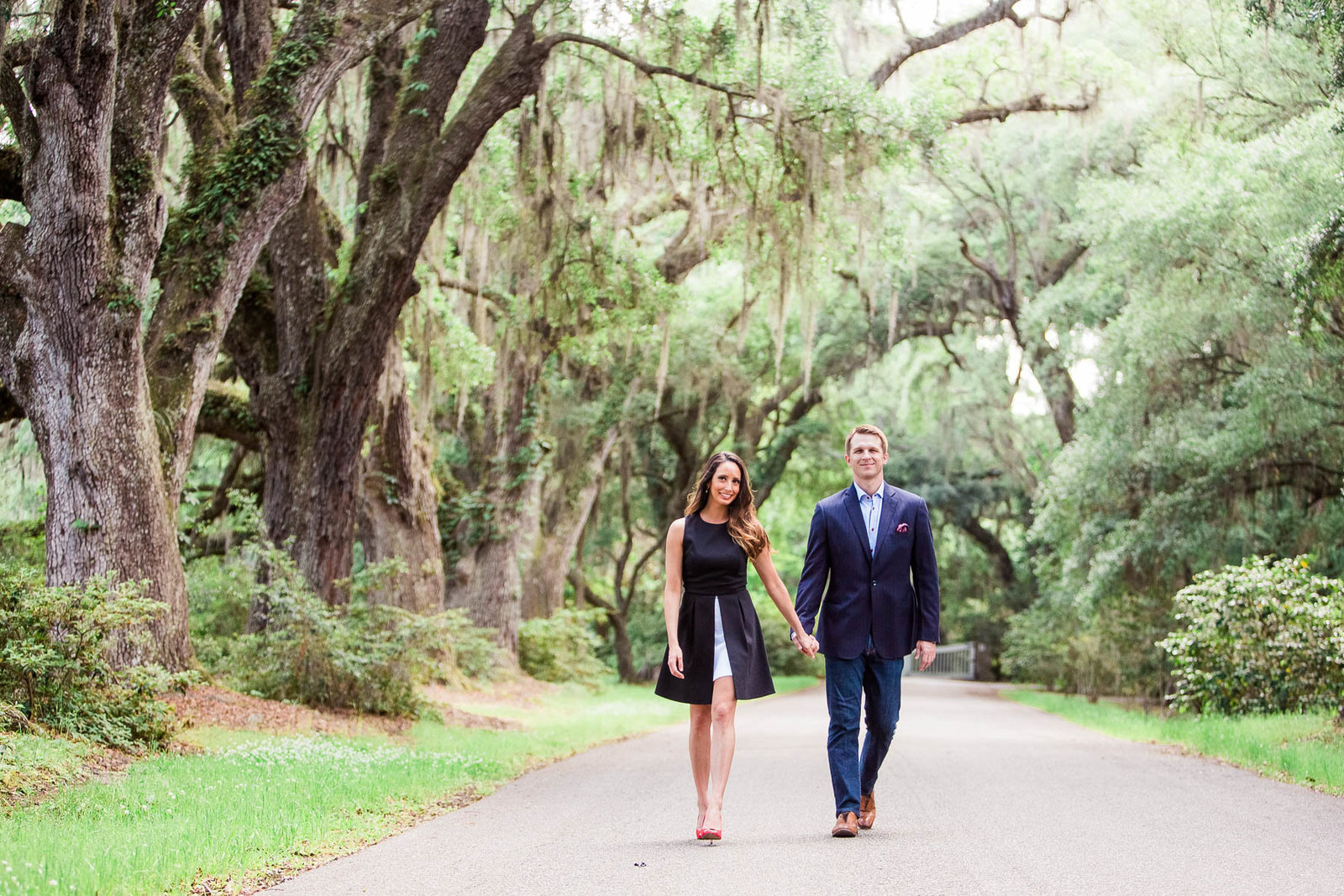 Engaged couple walks down road to the Avenue of Oaks, Magnolia Plantation, Charleston, South Carolina