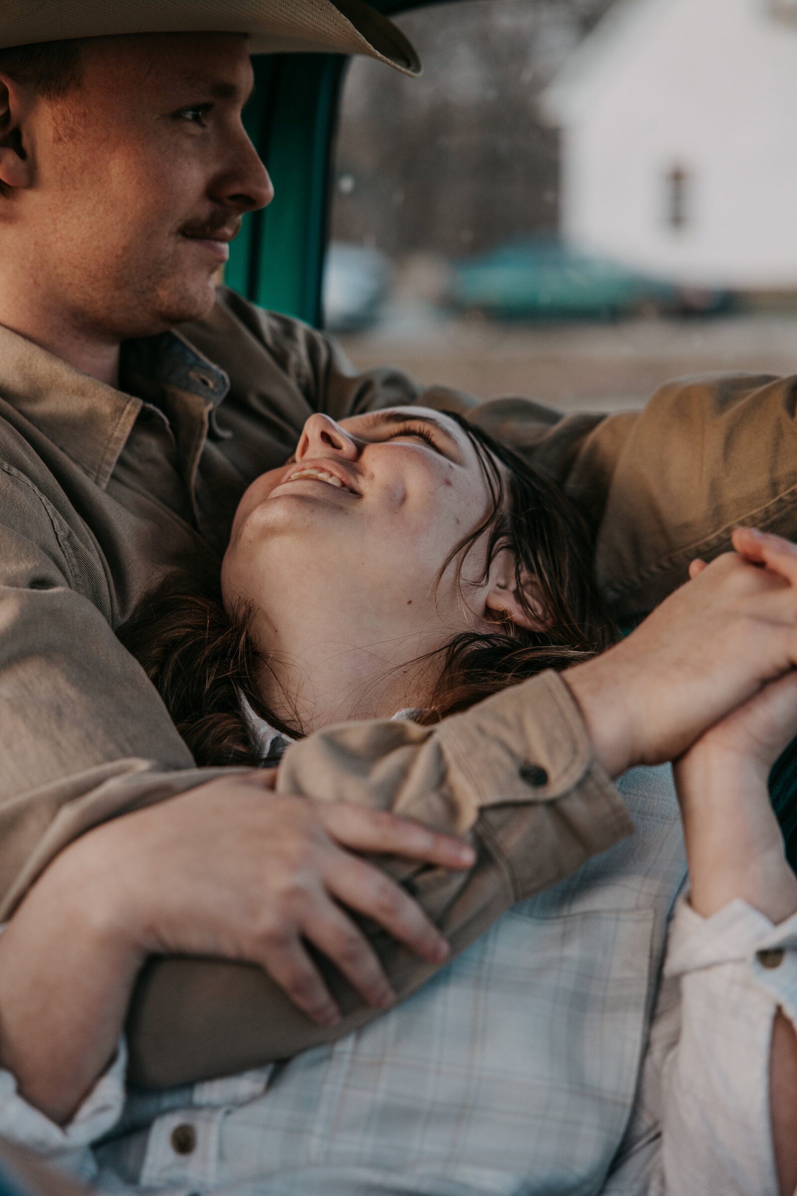 Laura looks up at Jacob lovingly while cuddling in the cab of his vintage truck.