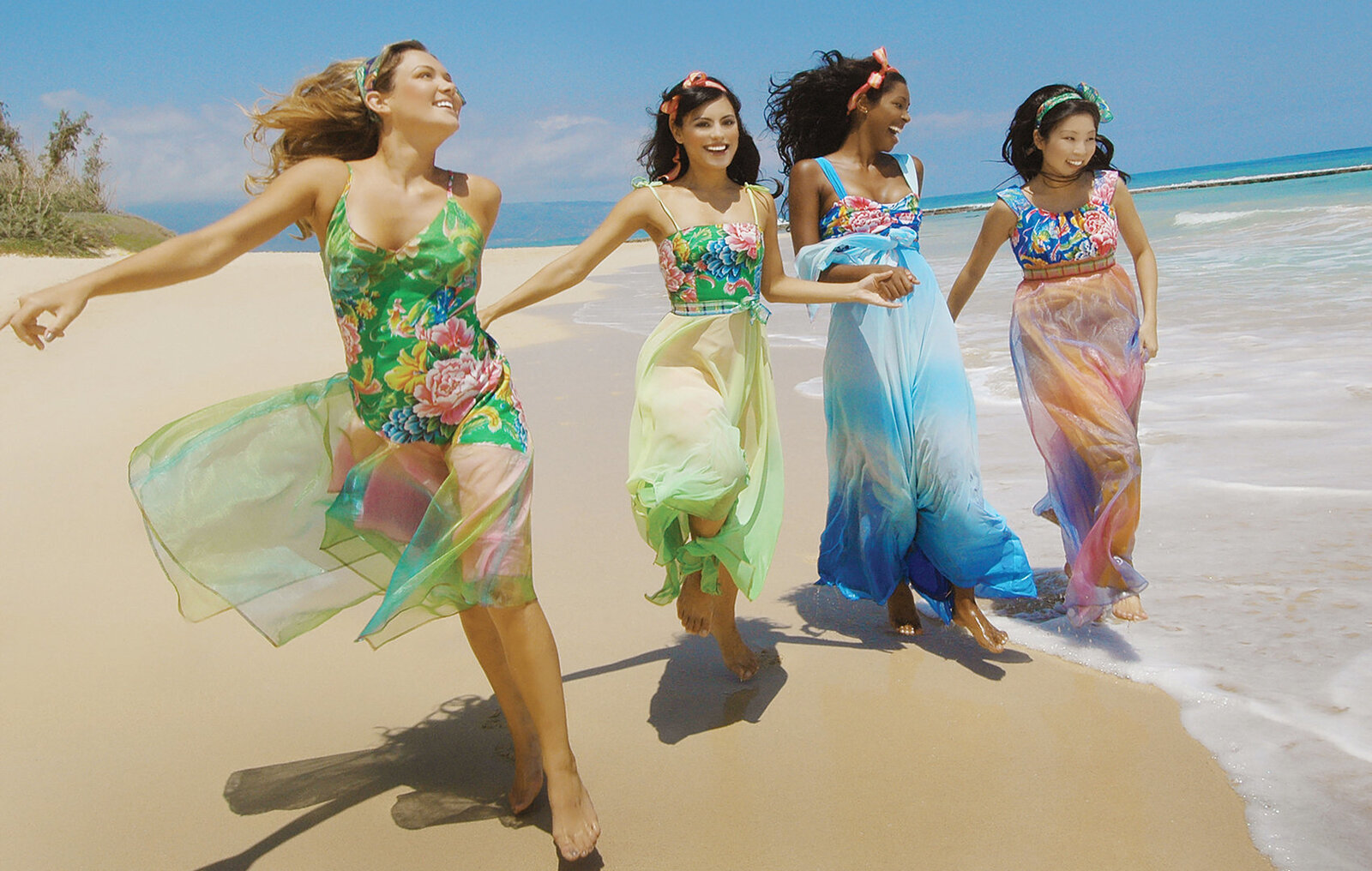 Four very brides maids running and skipping along the beach in Oahu 