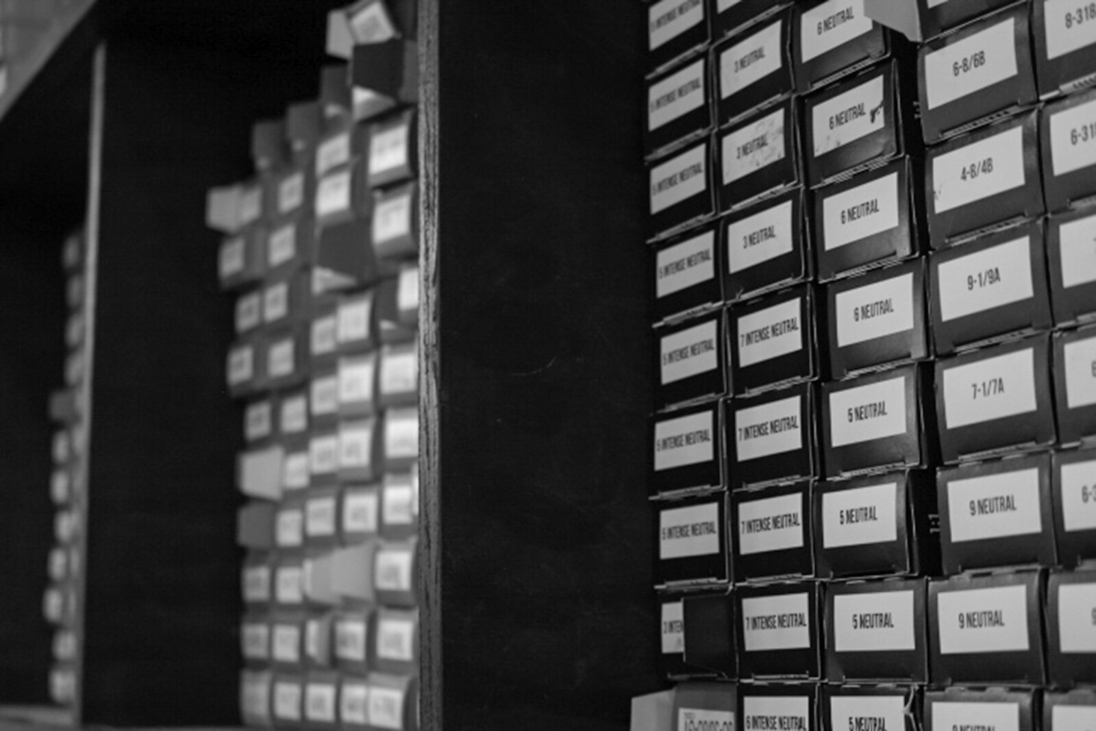 Hair color boxes on a shelf in a salon in black and white