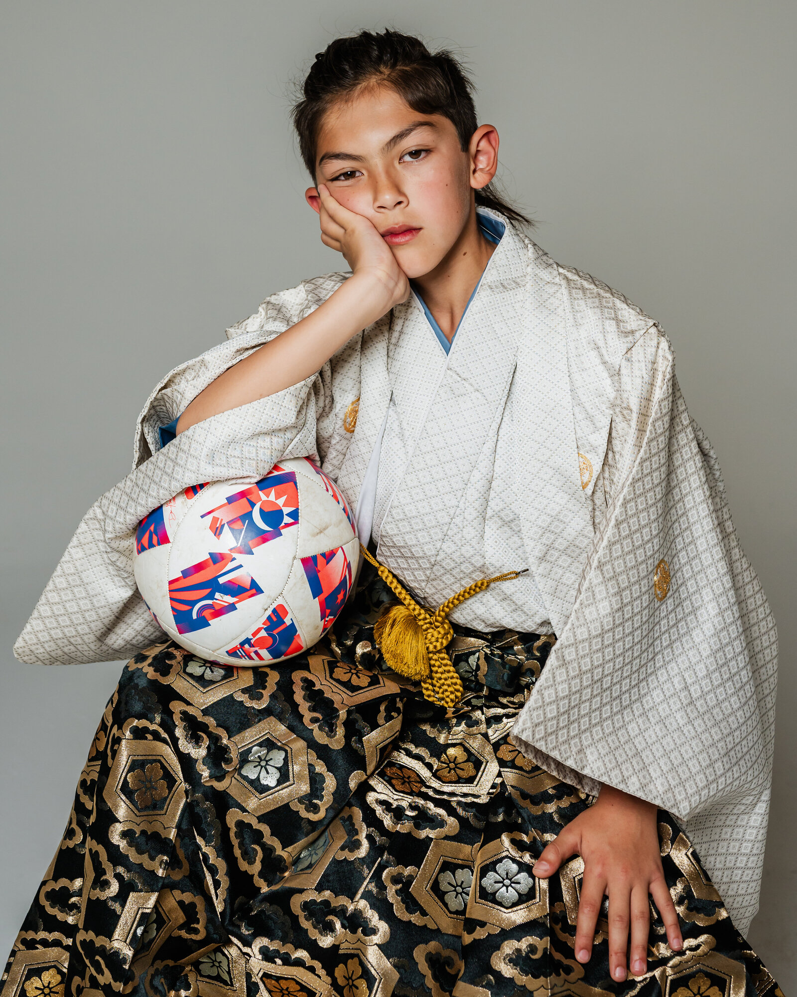 Boy in white kimono with gold crest and black-gold hakama holding soccer ball | 卒業式 男の子 白着物 金紋 黒金袴 サッカーボール