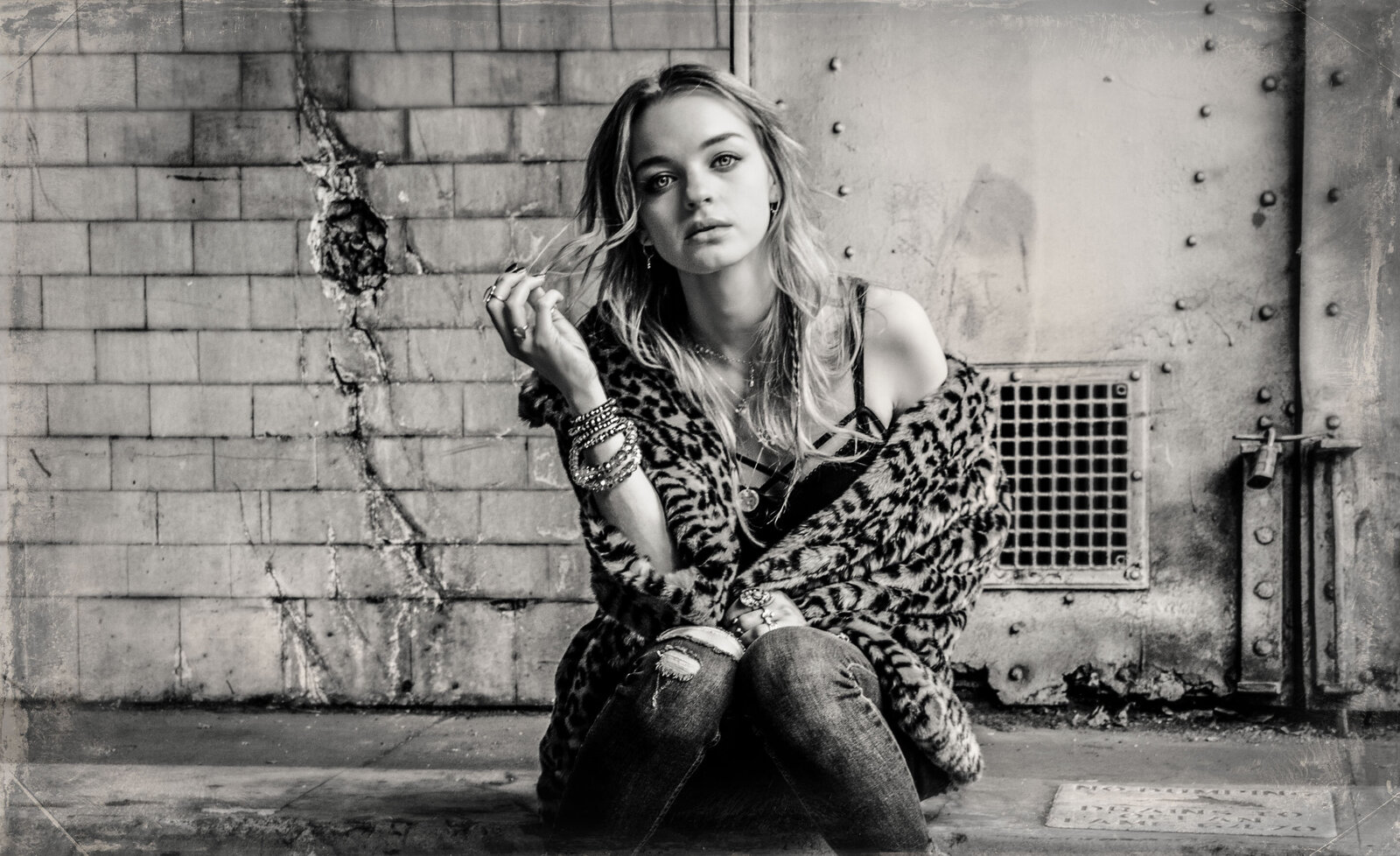 Music portrait Olivia Rose Keegan black and white  sitting on curb  with old door behind