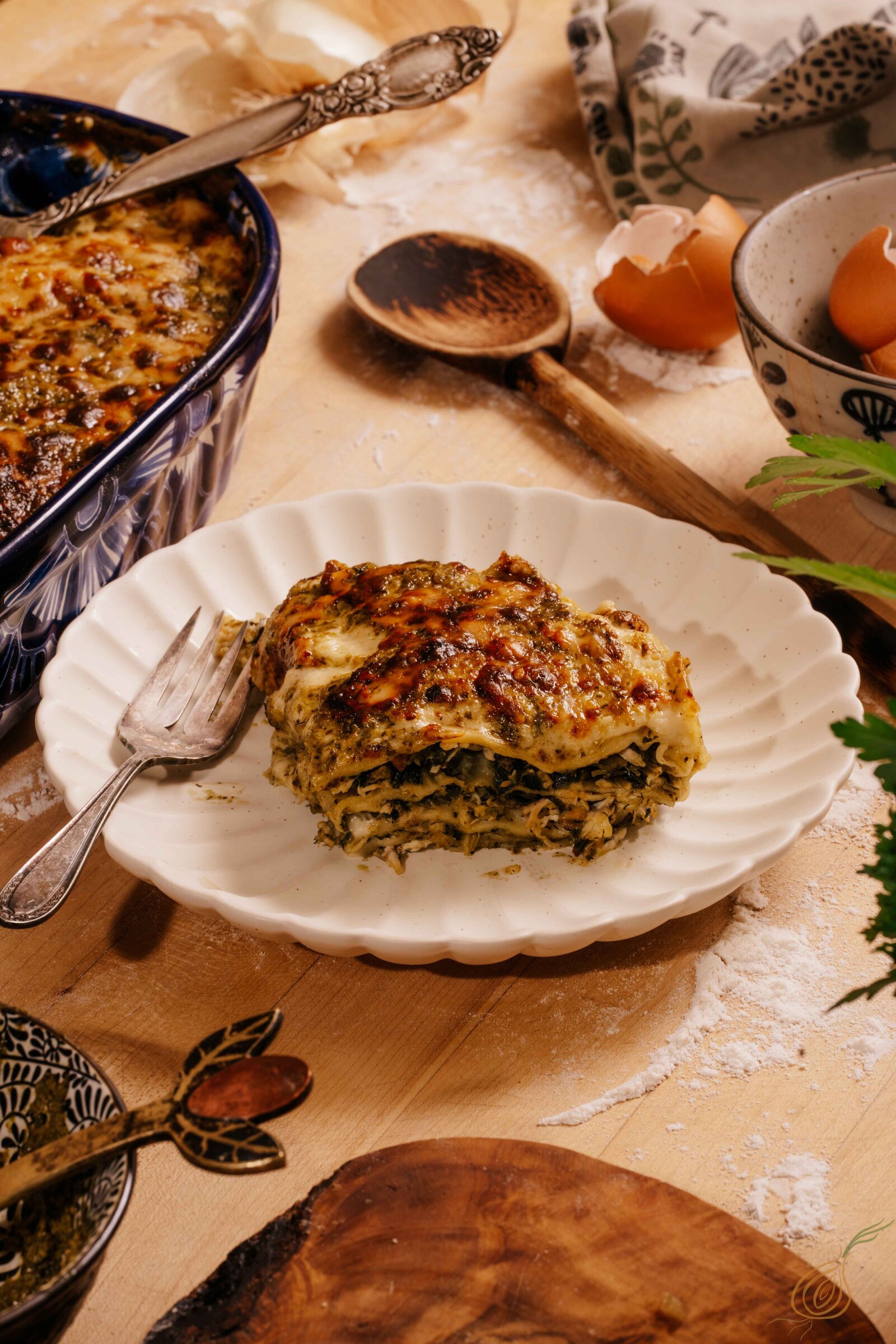 A white plate filled with a colorful lasagna dish, showcasing a variety of textures and ingredients.