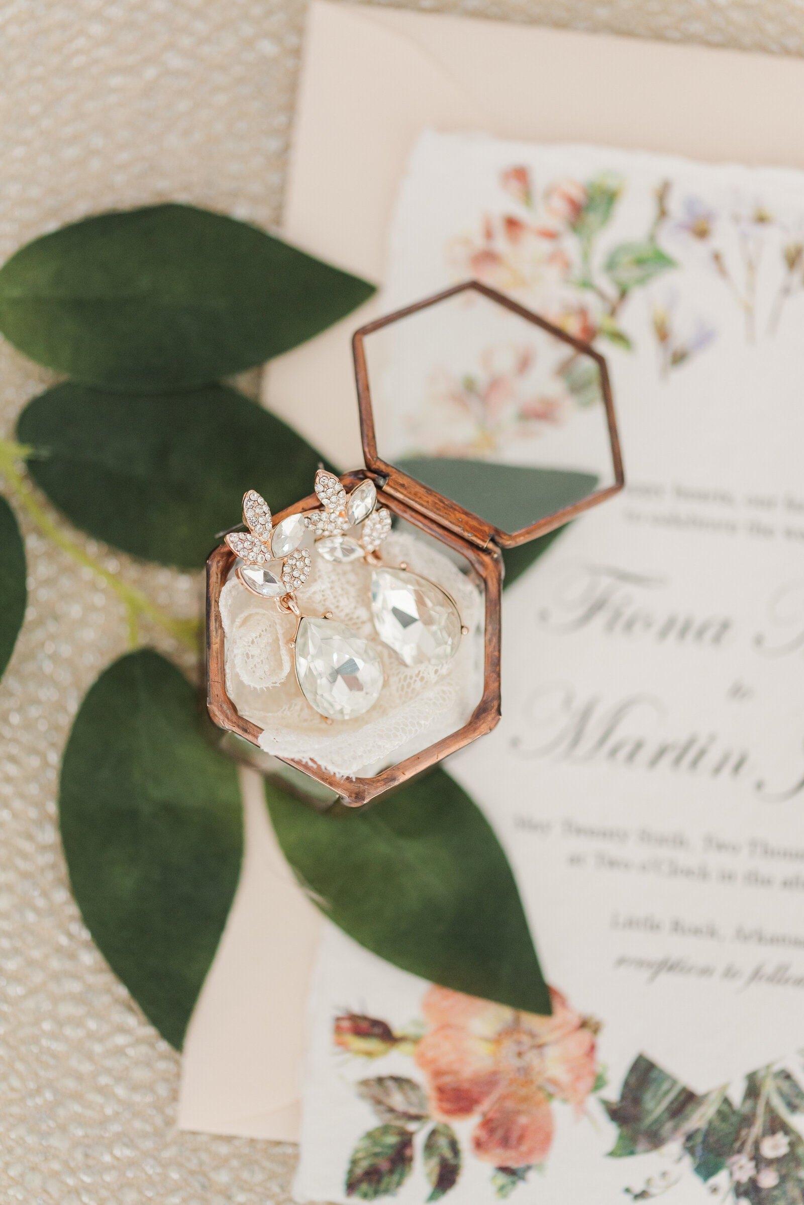 photo of brides earrings with greenery and invitation suite
