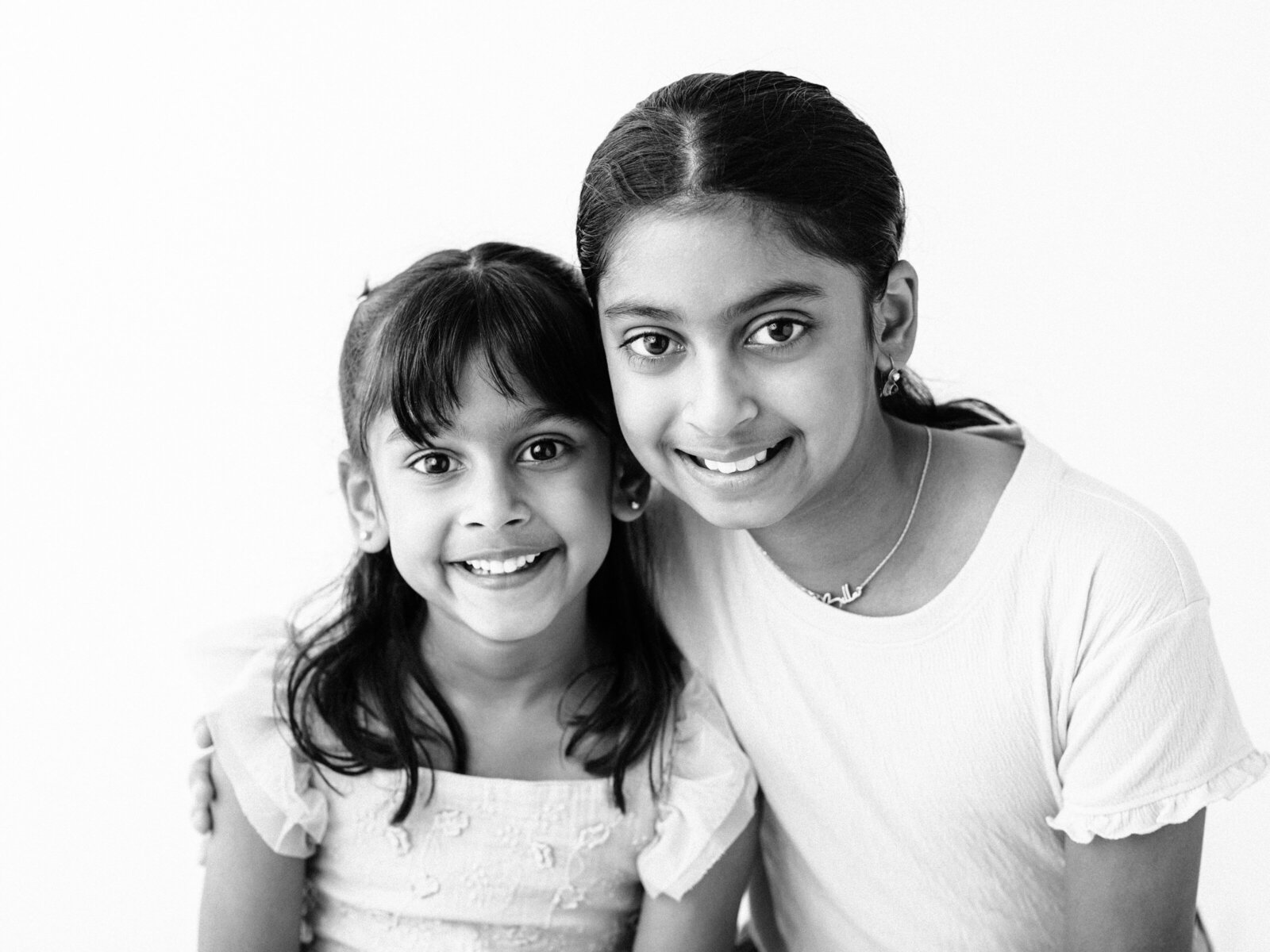 black and white photo of siblings posing for studio portraits