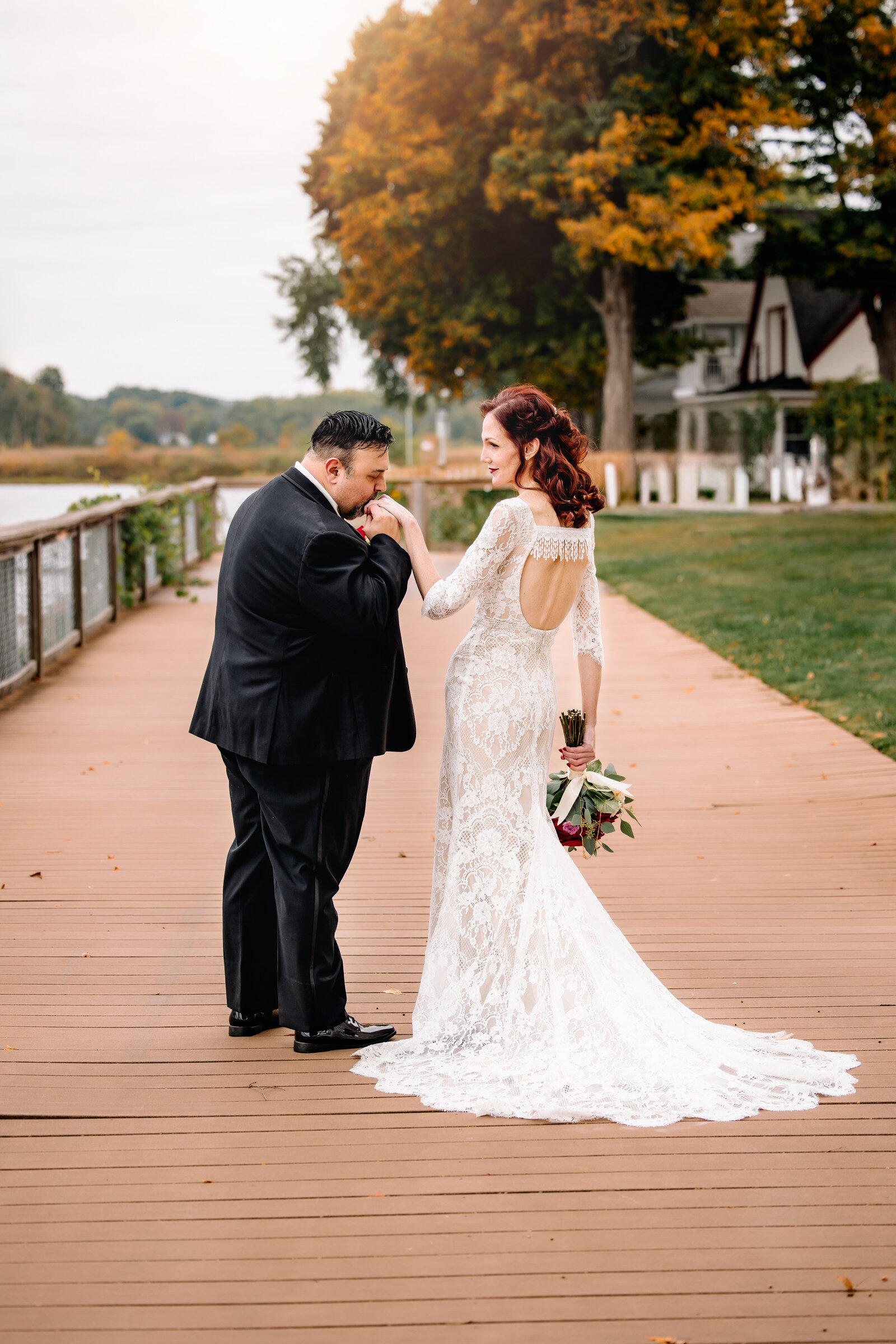 Groom tenderly kisses brides hand for a portrait on their wedding day
