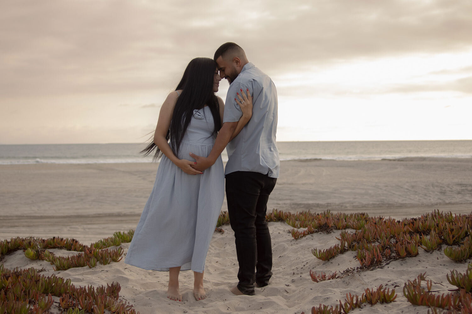 Expecting parents standing together on the beach