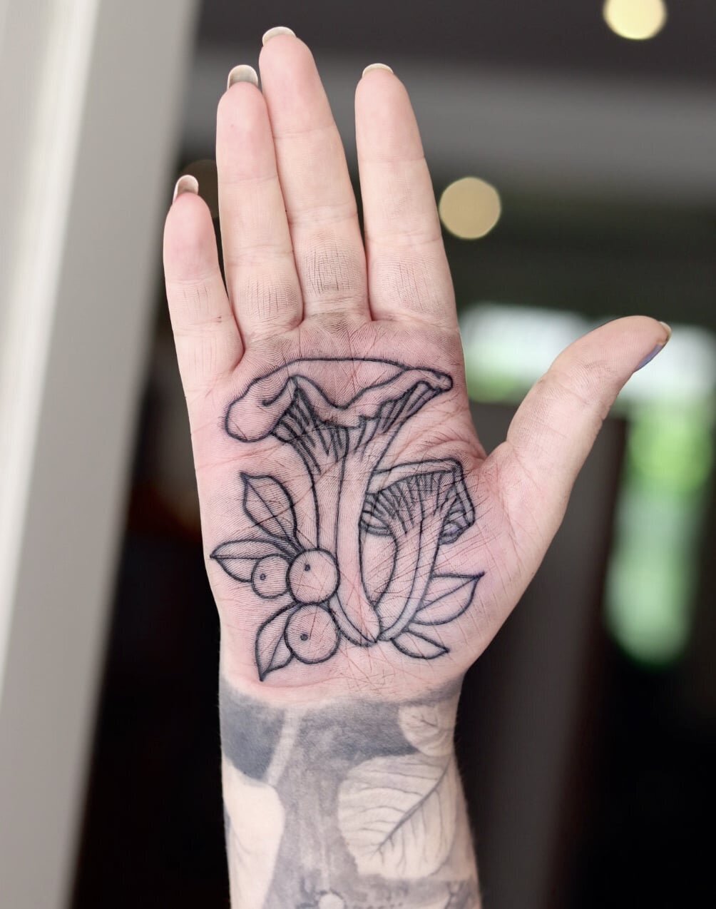 Tatuering i handflata av kantareller.