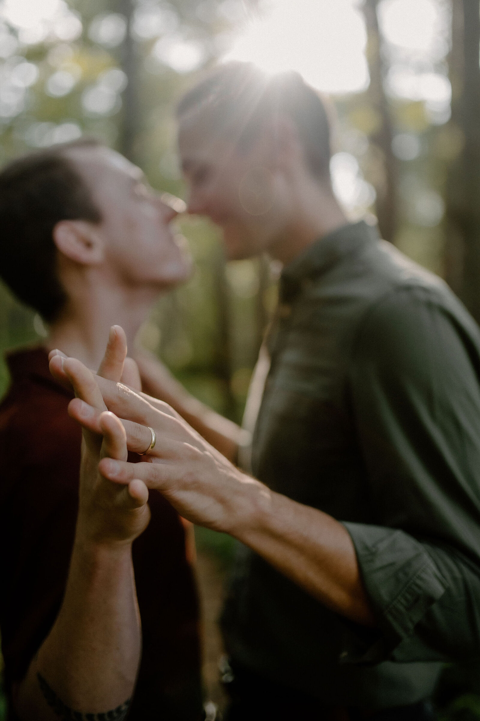 couple holding hands in outdoor forest holding hands fingers interlaced wedding ring close up