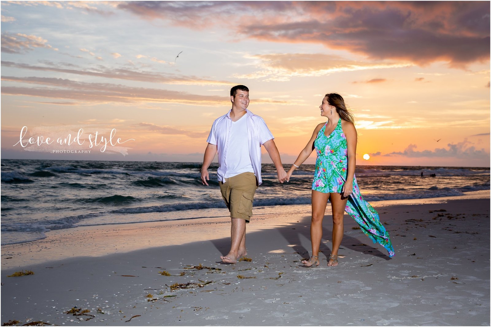 Engagement Photography on Bradenton Beach during sunset with couple holding hands and walking on the beach