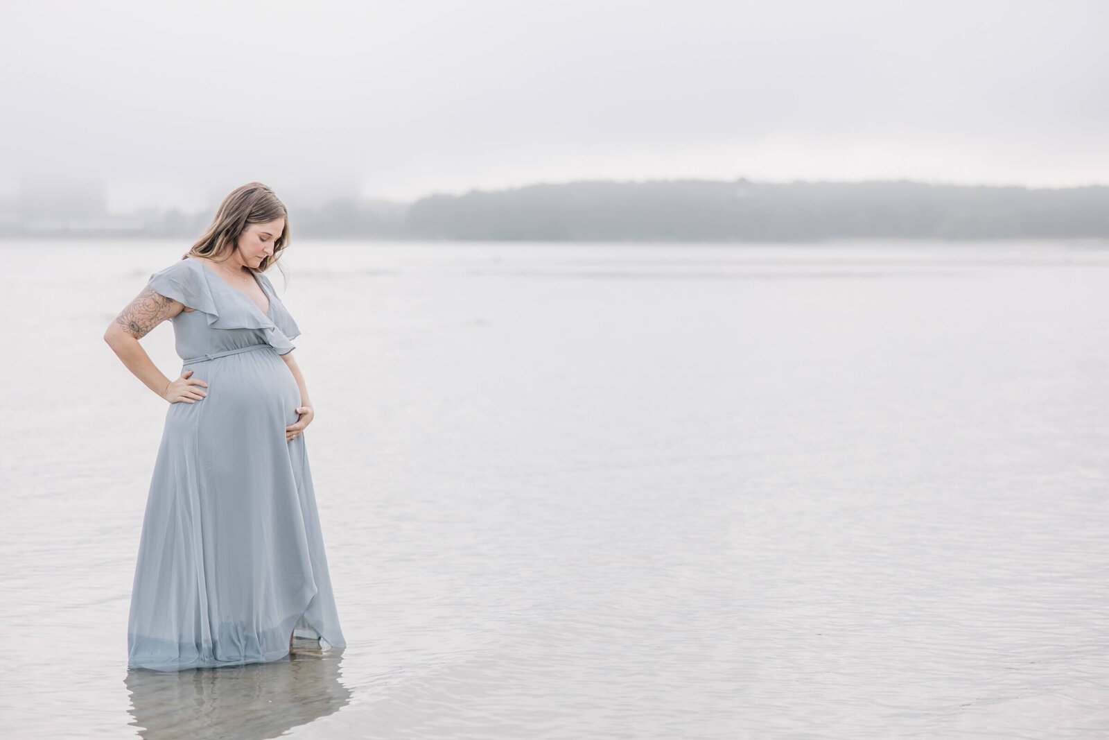 Pregnant woman in shallow water in light blue dress