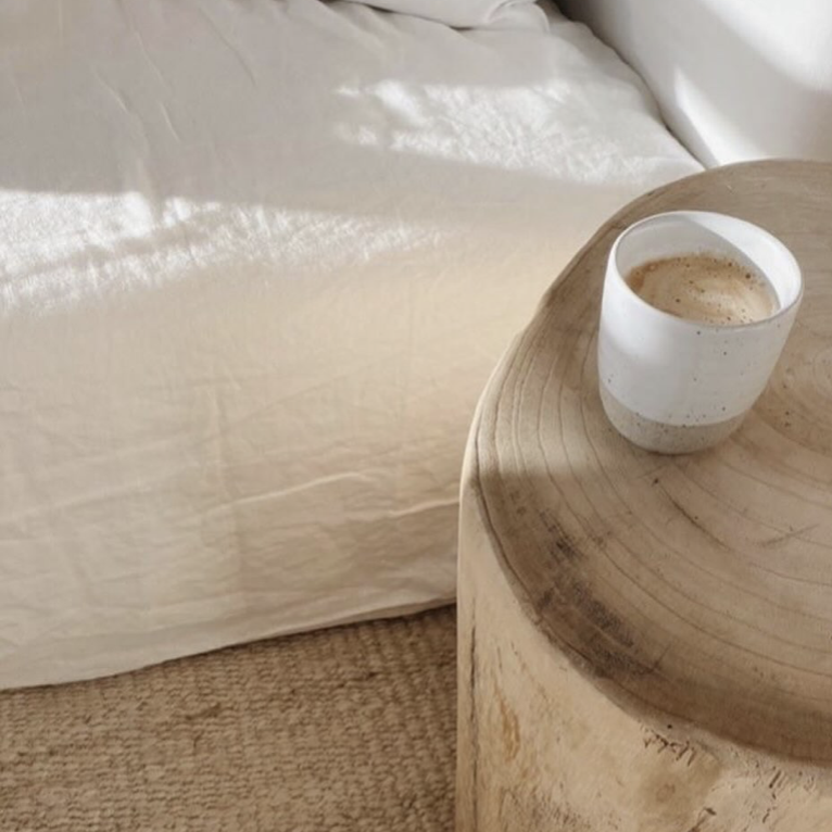 Tasse cafe en ceramique artisanale posee sur table de chevet en bois