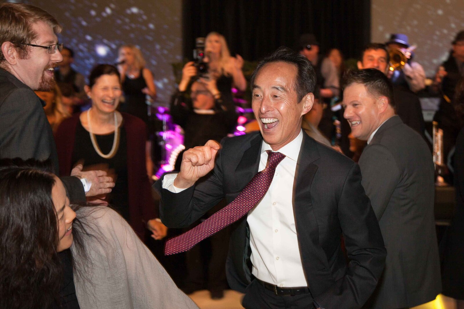 Holiday party man laughing on dance floor.-