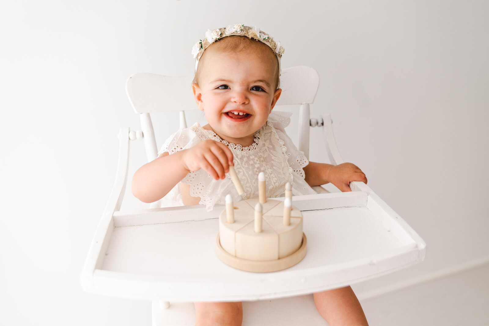 baby playing with wooden cake